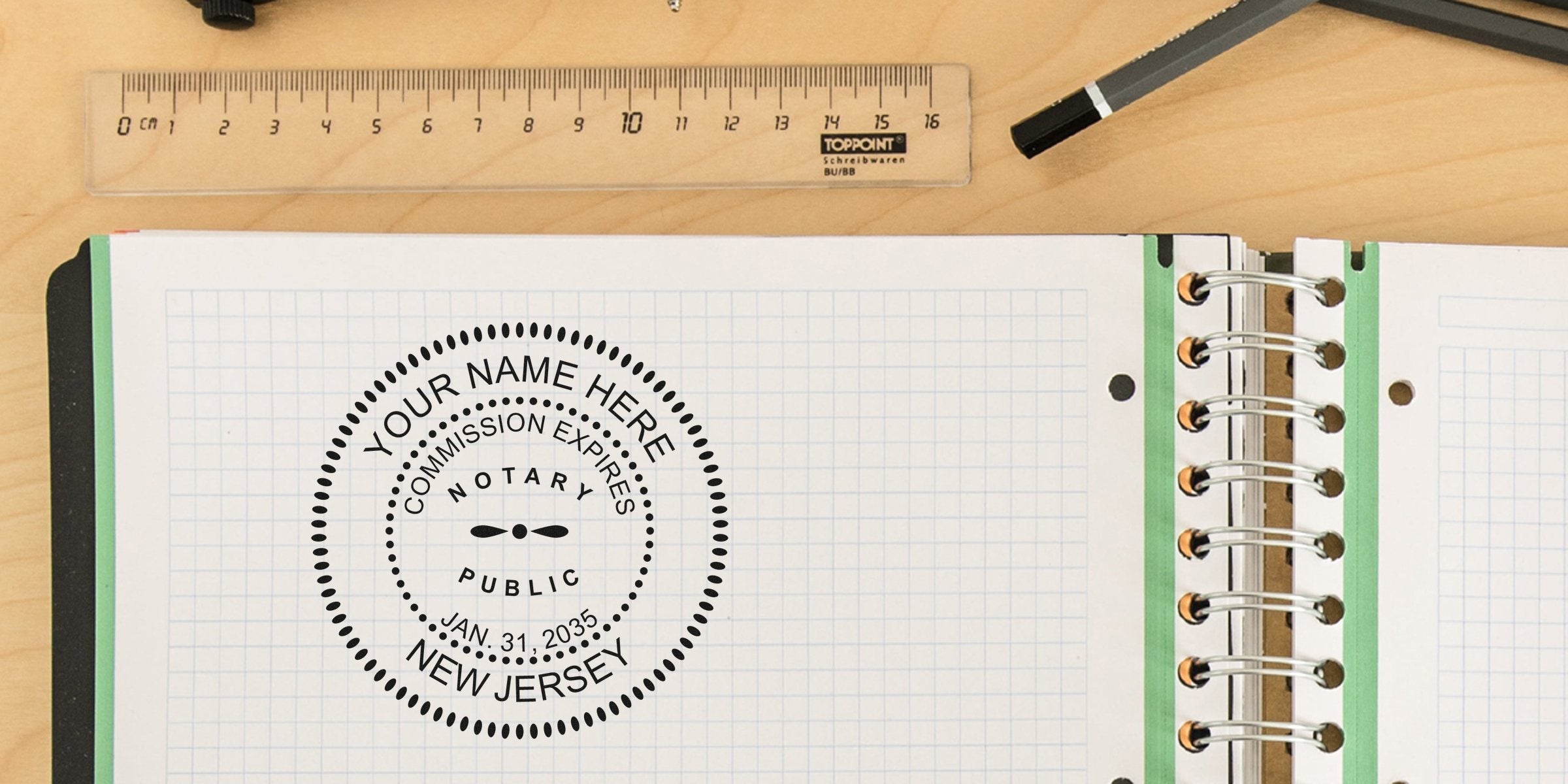 Top-down view of open spiral notebook with graph paper showing a circular notary stamp reading "Your Name Here, New Jersey", plus a clear ruler and black pen on a light wood desk, office stationery composition