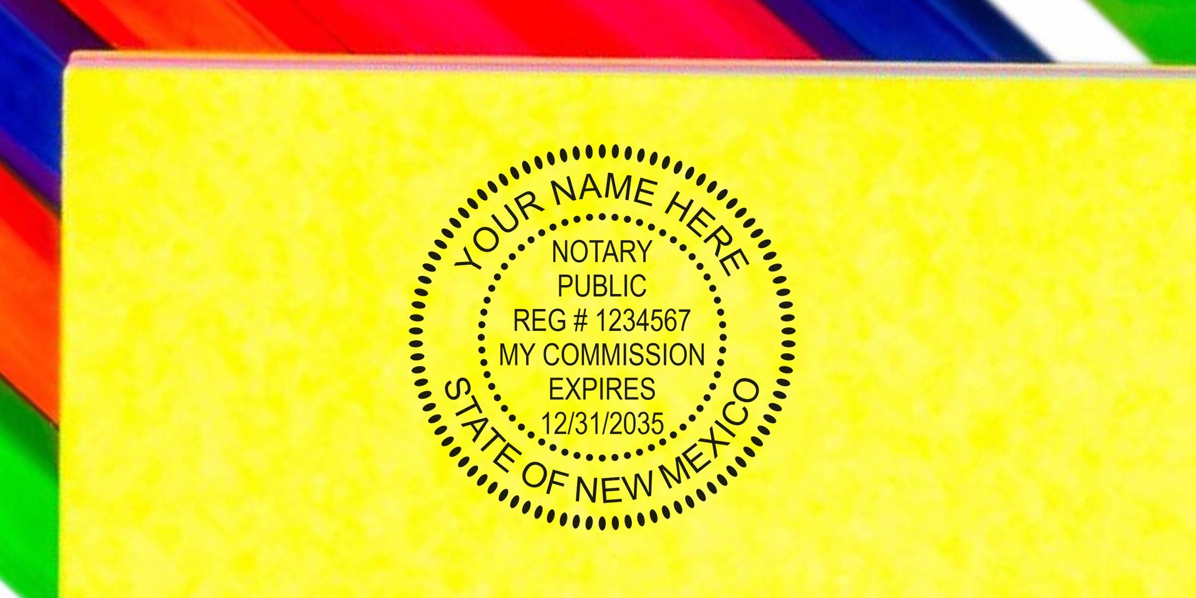 Round black notary public seal stamp on yellow paper reading "YOUR NAME HERE, NOTARY PUBLIC, REG #1234567, MY COMMISSION EXPIRES 12/31/2035, STATE OF NEW MEXICO" with multicolor corner accents