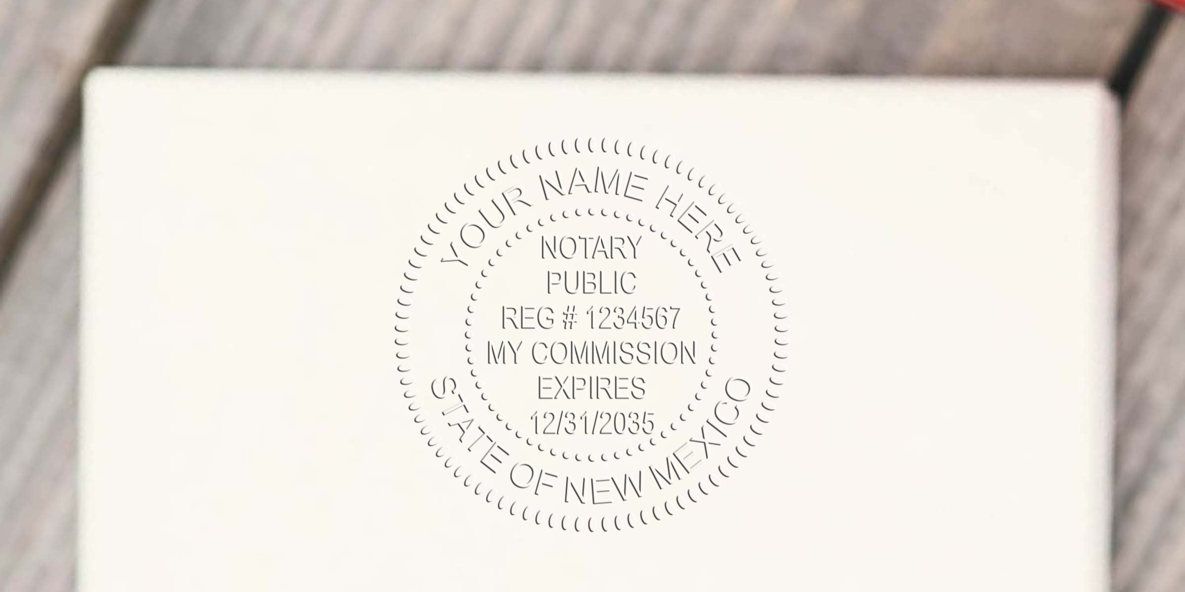Embossed notary public seal on white paper reading "YOUR NAME HERE, NOTARY PUBLIC, REG # 1234567, MY COMMISSION EXPIRES 12/31/2035, STATE OF NEW MEXICO."