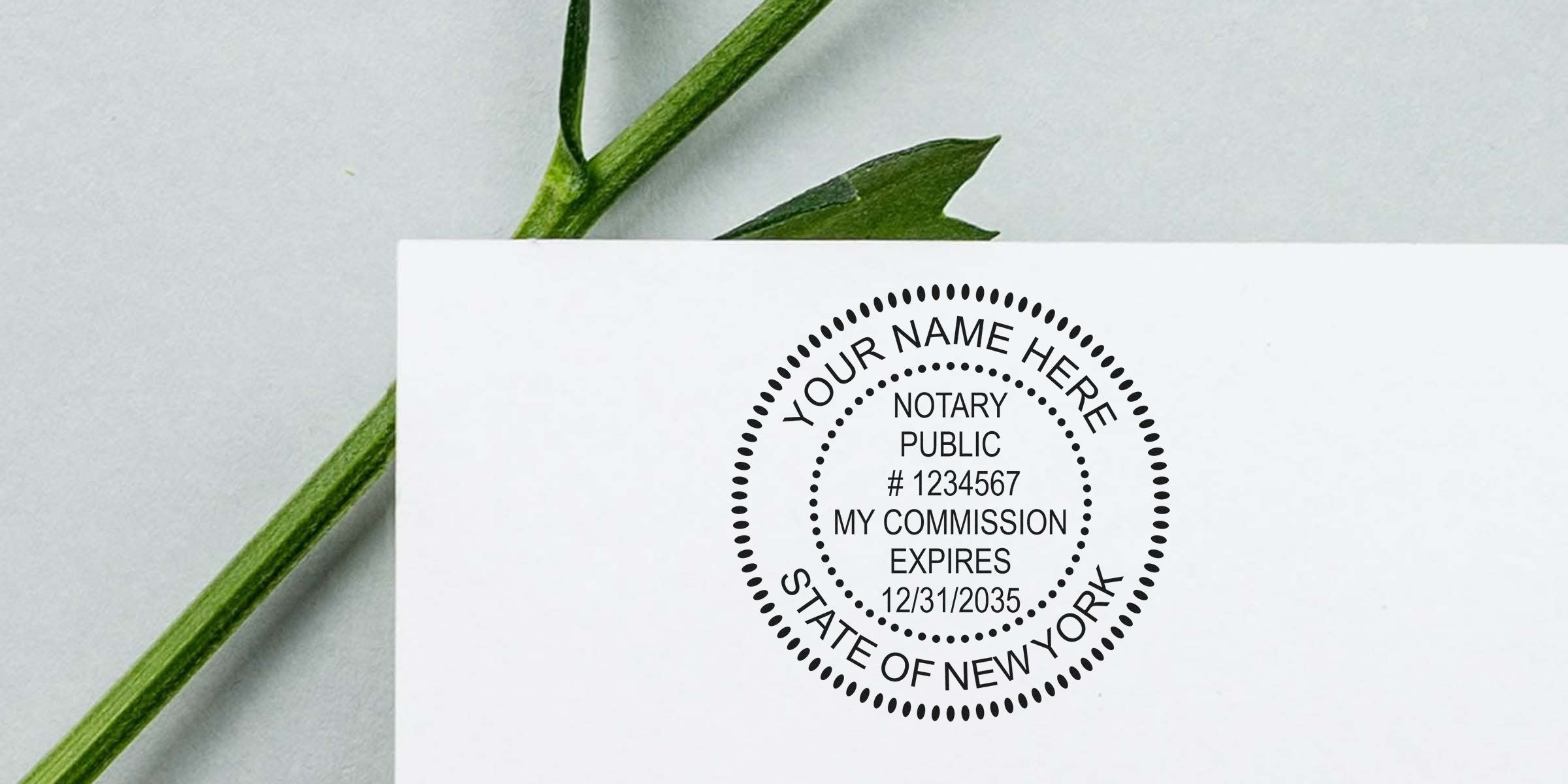 Close-up of a round New York notary public stamp on white paper showing placeholder name, commission number and expiration date, placed beside a green leaf and stem on a light gray background