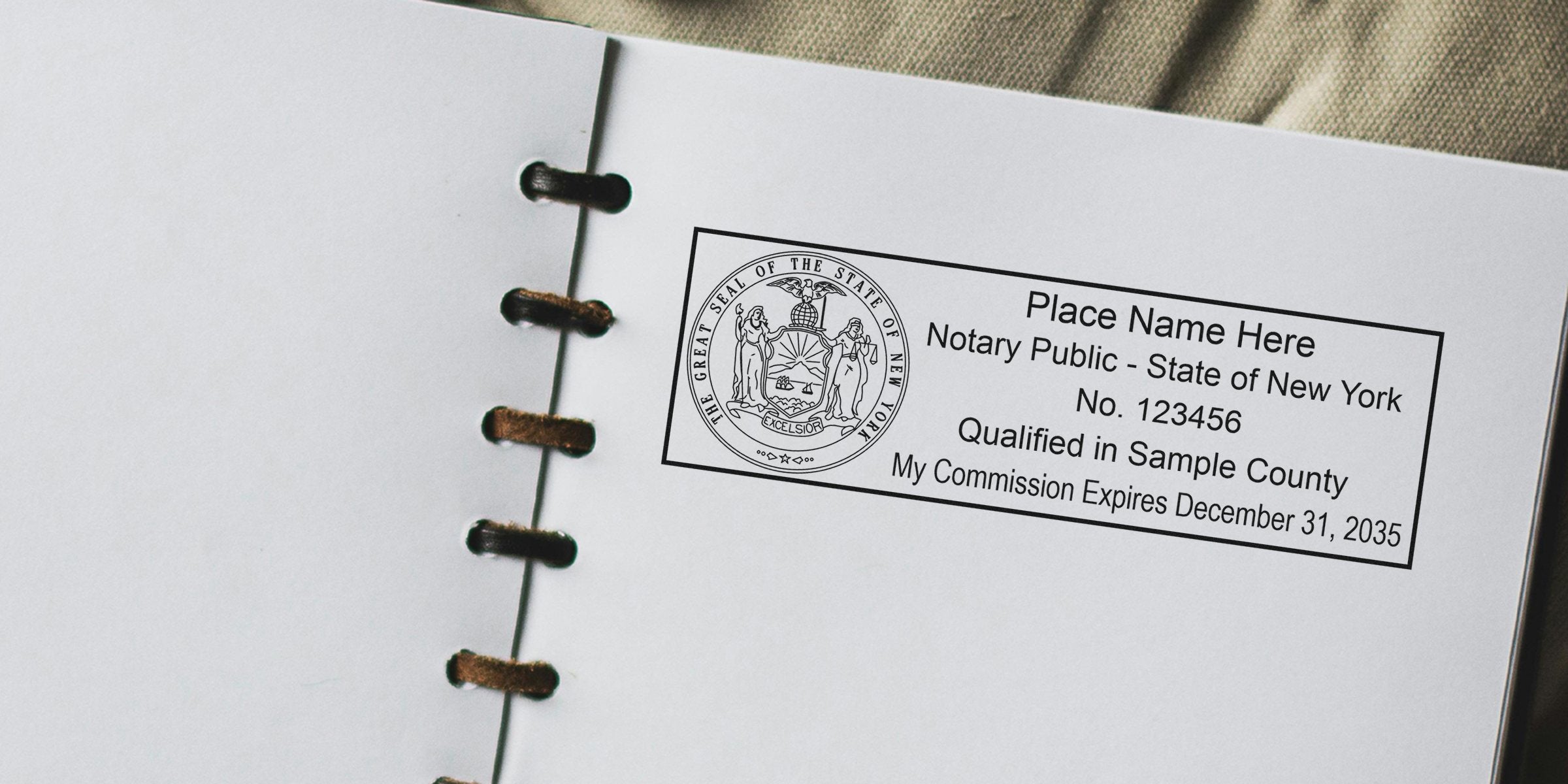 Close-up of a Notary Public stamp template on an open spiral notebook page featuring the New York state seal, placeholder name, commission number and expiration date for document authentication