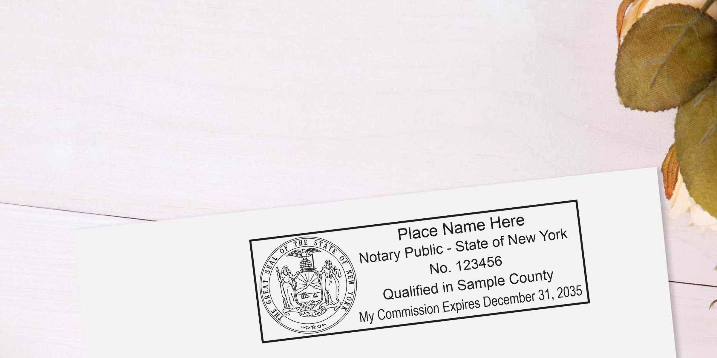 Sample notary public stamp with New York state seal, placeholder name, commission number, county qualification and expiration date on white paper, angled on pale wooden background with green leaves visible at edge
