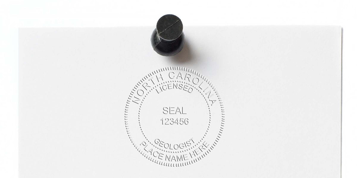 North Carolina geologist seal embossed on white paper, pinned with a black thumbtack.