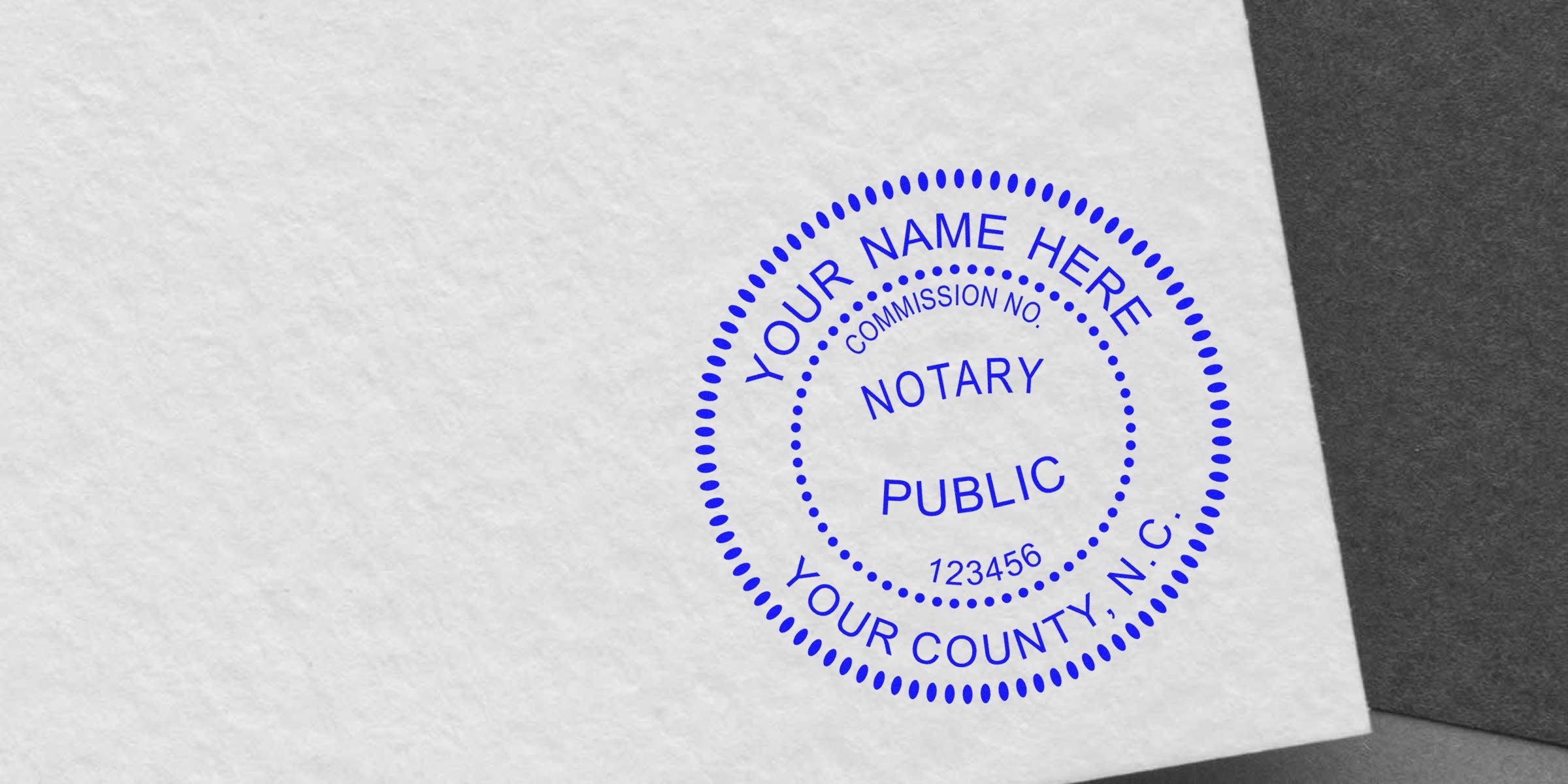 Blue circular notary public stamp mockup on textured white paper reading "Your Name Here," commission number and county, official seal design