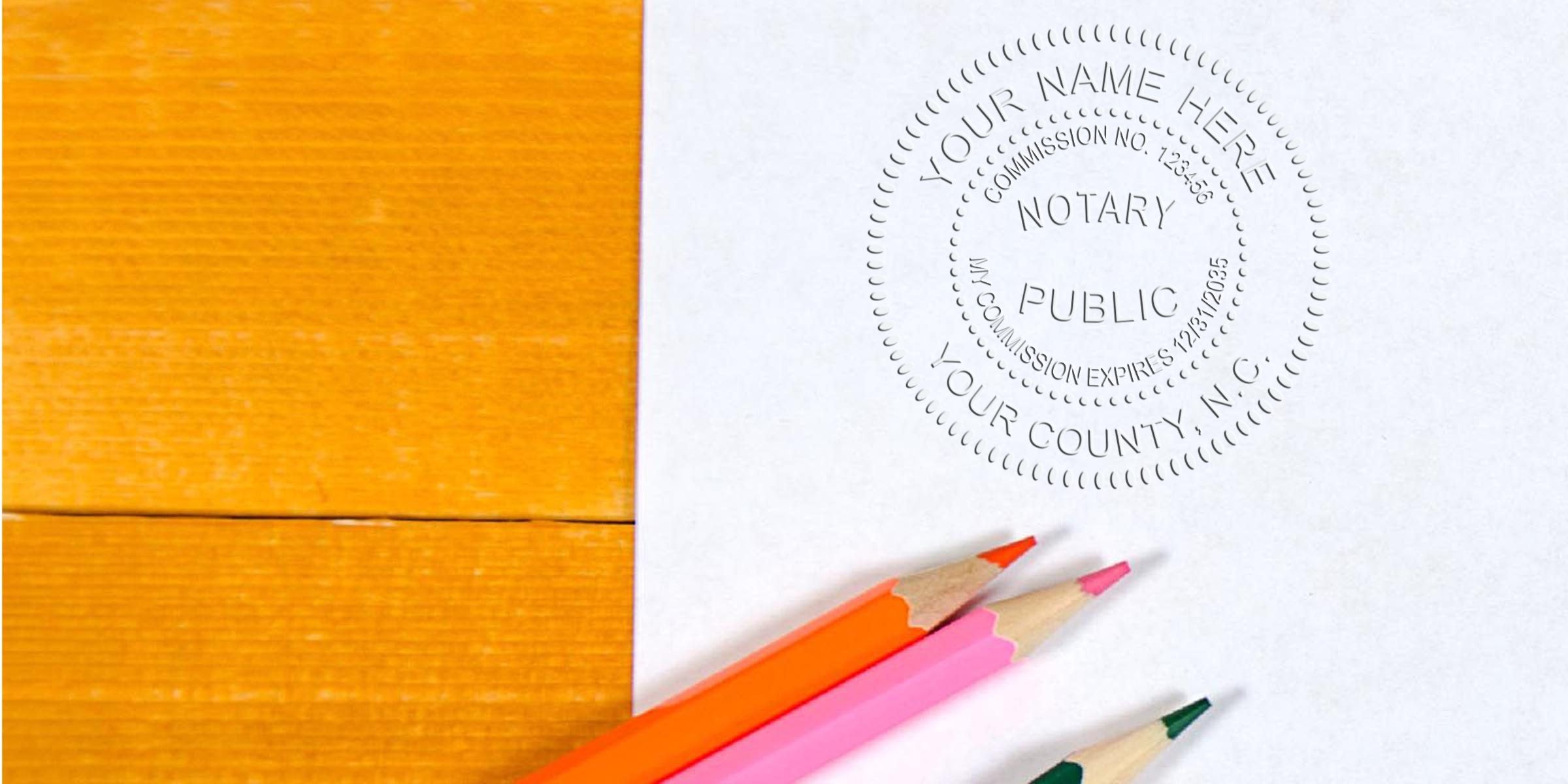 Embossed notary public seal on white paper beside orange, pink and green colored pencils on a honey-colored wooden desk