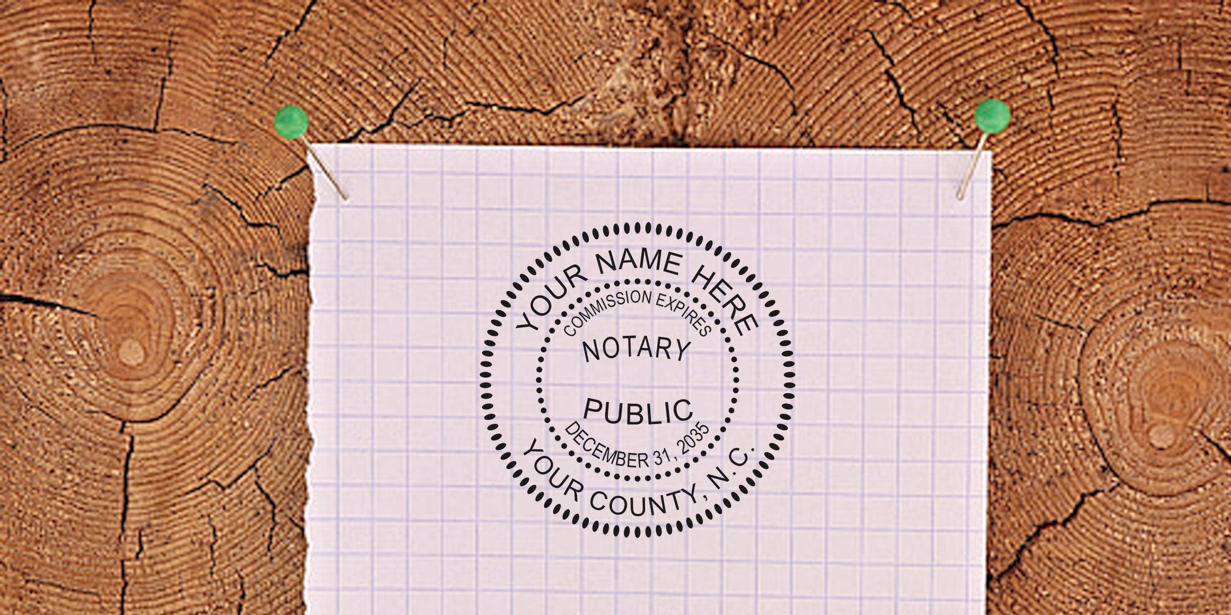 Notary public circular seal stamped on graph paper pinned with green pushpins to a textured wooden log cross-section background