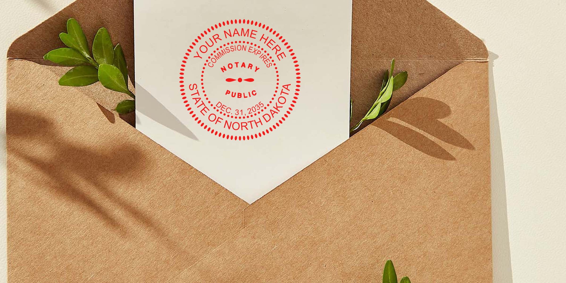 Kraft paper envelope with white card showing a red "Notary Public State of North Dakota" seal, green leaves tucked inside, natural shadow and minimalist stationery styling