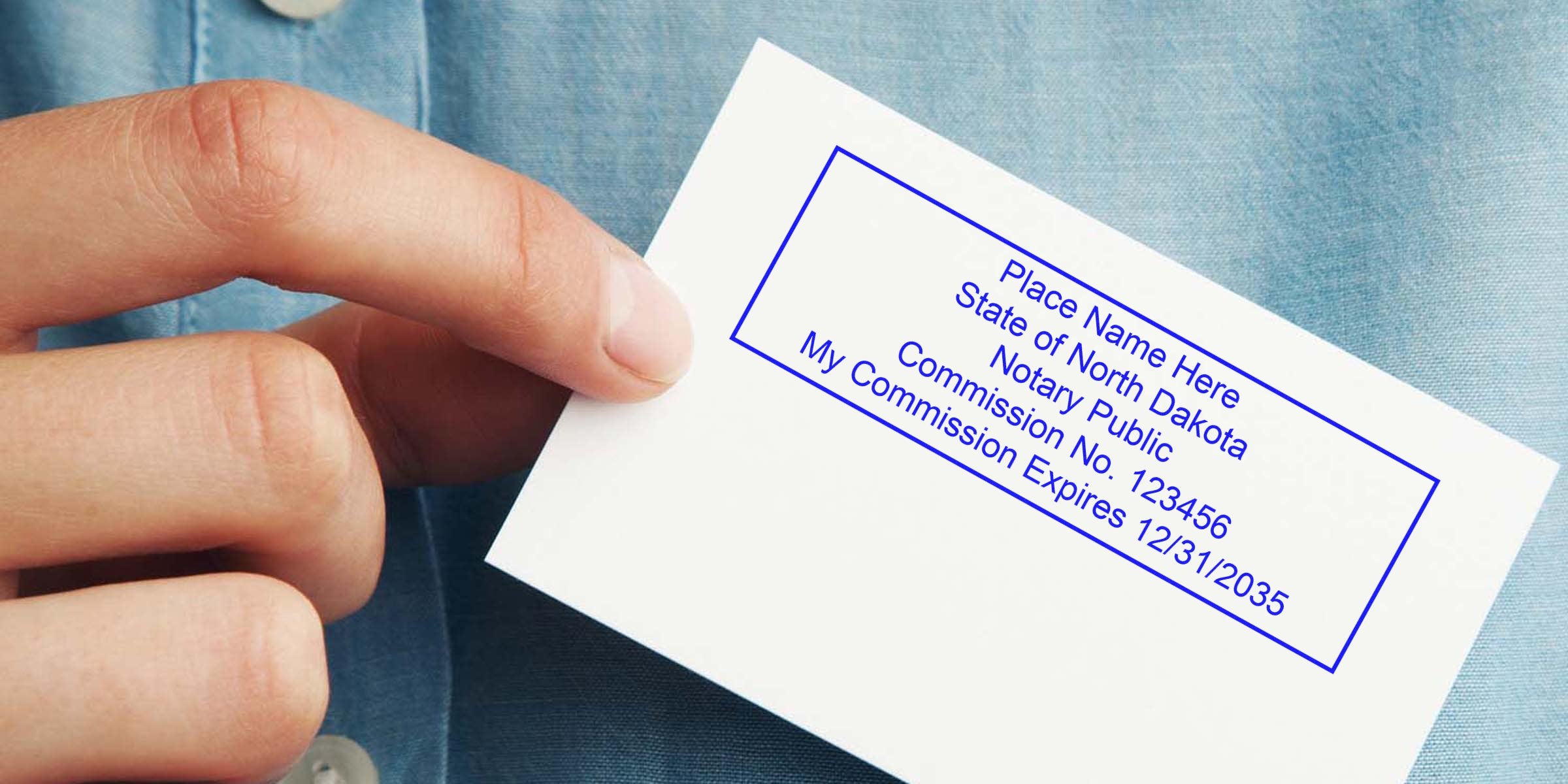 Hand holding a white business card with a blue notary stamp reading "Place Name Here, State of North Dakota, Notary Public, My Commission No. 123456, Expires 12/31/2035" against a light blue shirt background