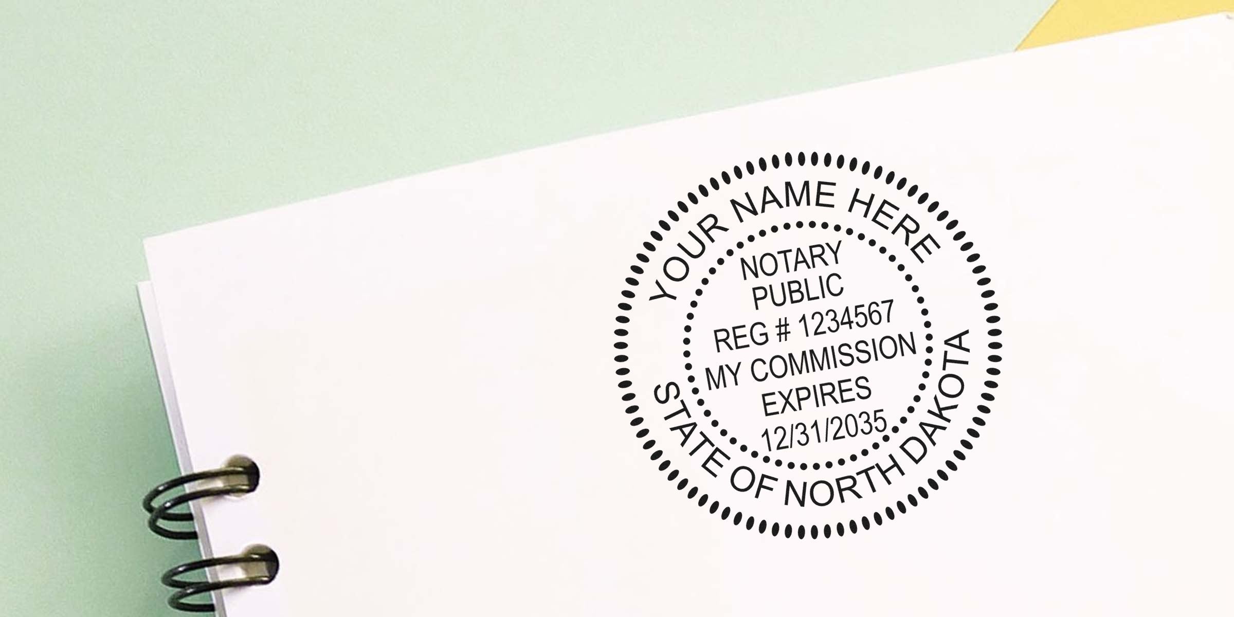 Close-up of a round notary public stamp seal reading "Notary Public" and "State of North Dakota" printed on white notebook paper next to spiral binding