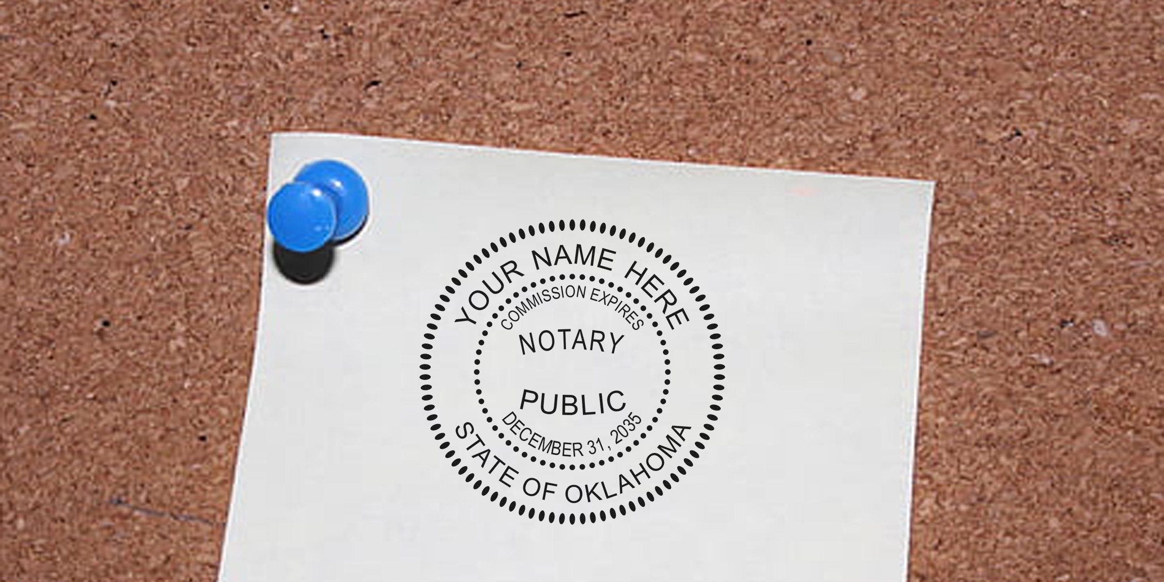 White paper pinned by a blue pushpin to a cork bulletin board, showing a circular notary public seal stamp reading "Notary Public, State of Oklahoma" with placeholder "Your Name Here."