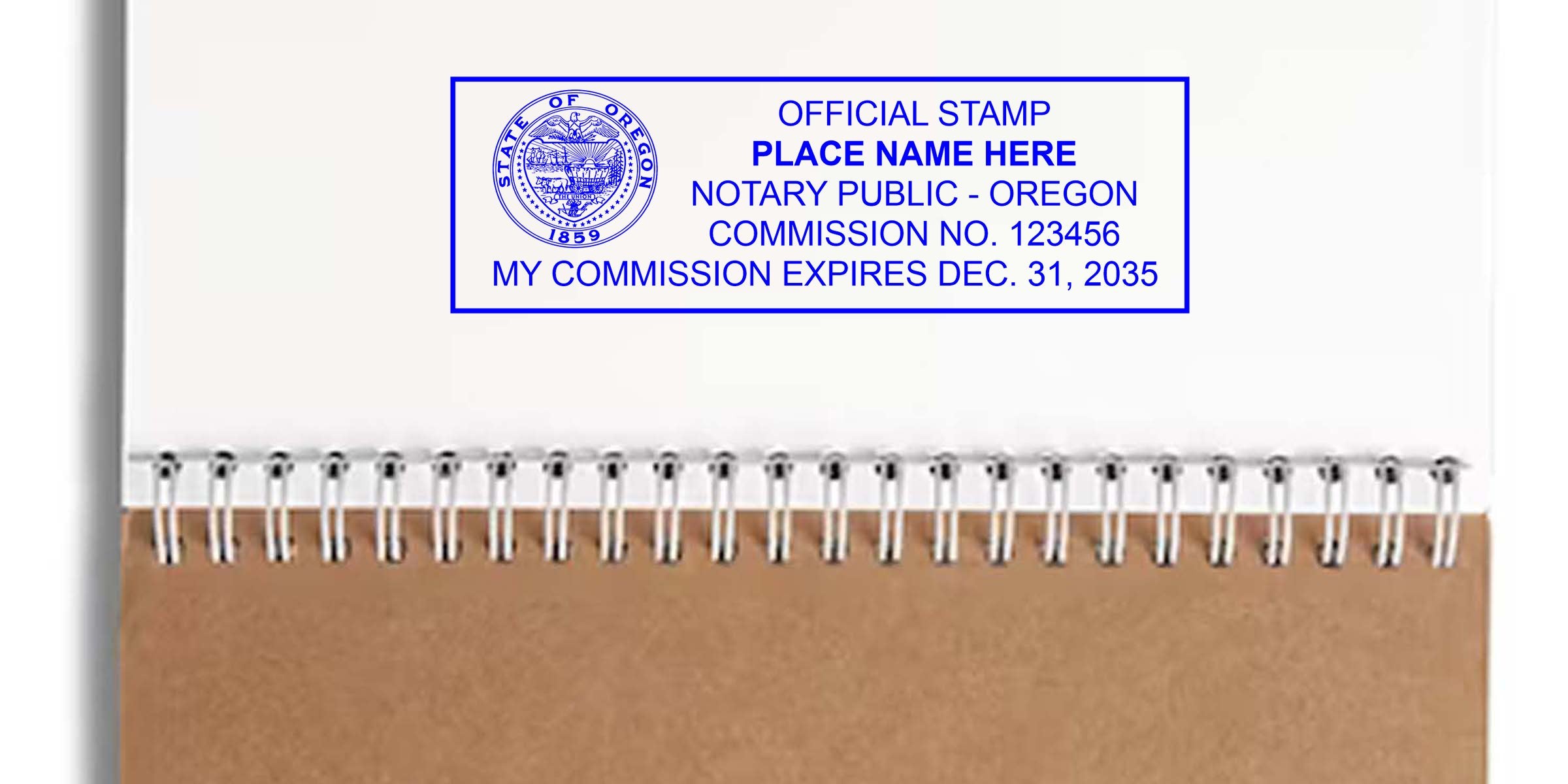 Blue rectangular Oregon notary public stamp on white paper above a spiral-bound kraft notebook cover, showing state seal, placeholder name, commission number and expiration date.