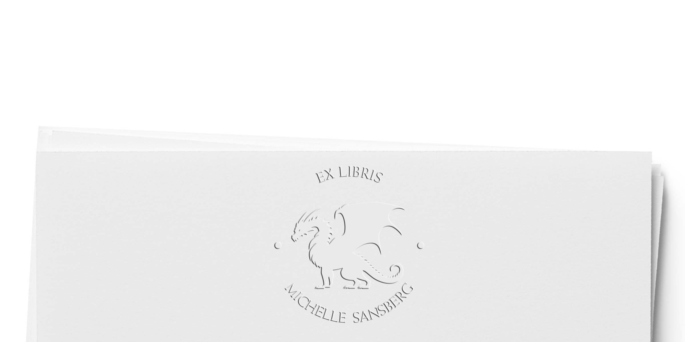 Embossed ex libris bookplate with a dragon motif and the name Michelle Sansberg.