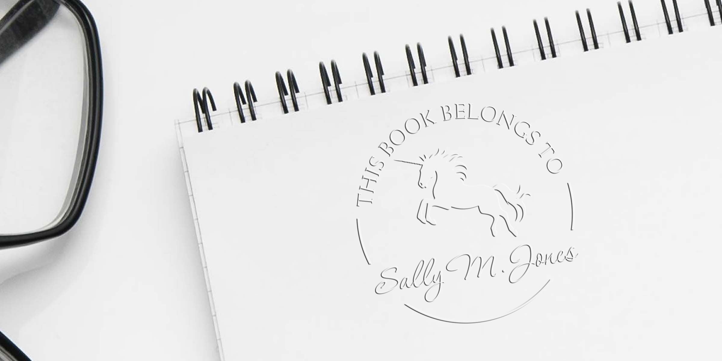 Spiral notebook with a unicorn logo and the text “This Book Belongs To Sally M. Jones.”