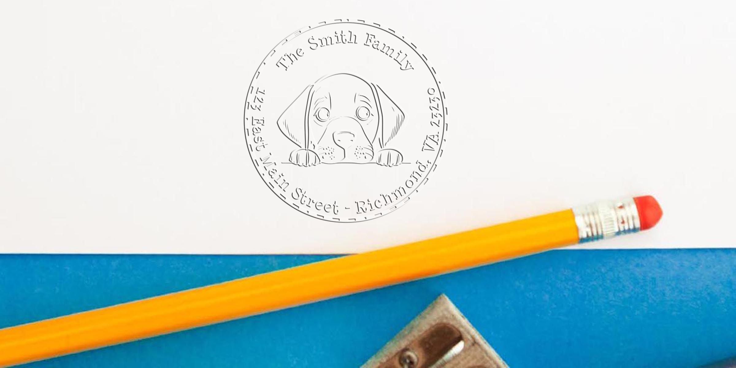 Cute puppy peeking over a white surface with a circular seal, a yellow pencil, and a sharpener on blue paper.