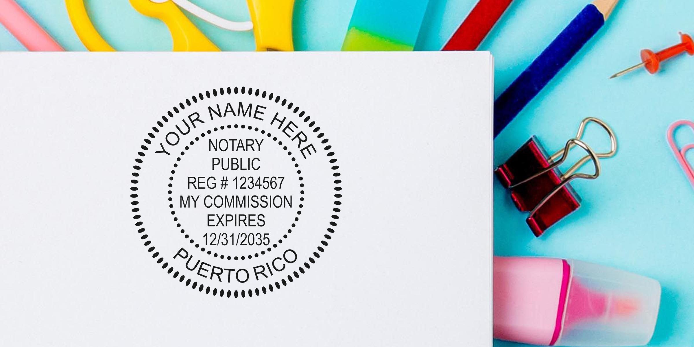 Round notary public stamp mockup on white paper reading "Your Name Here, Notary Public Reg #1234567 My Commission Expires 12/31/2035 Puerto Rico" with colorful office supplies, binder clip and pushpin on a blue background.