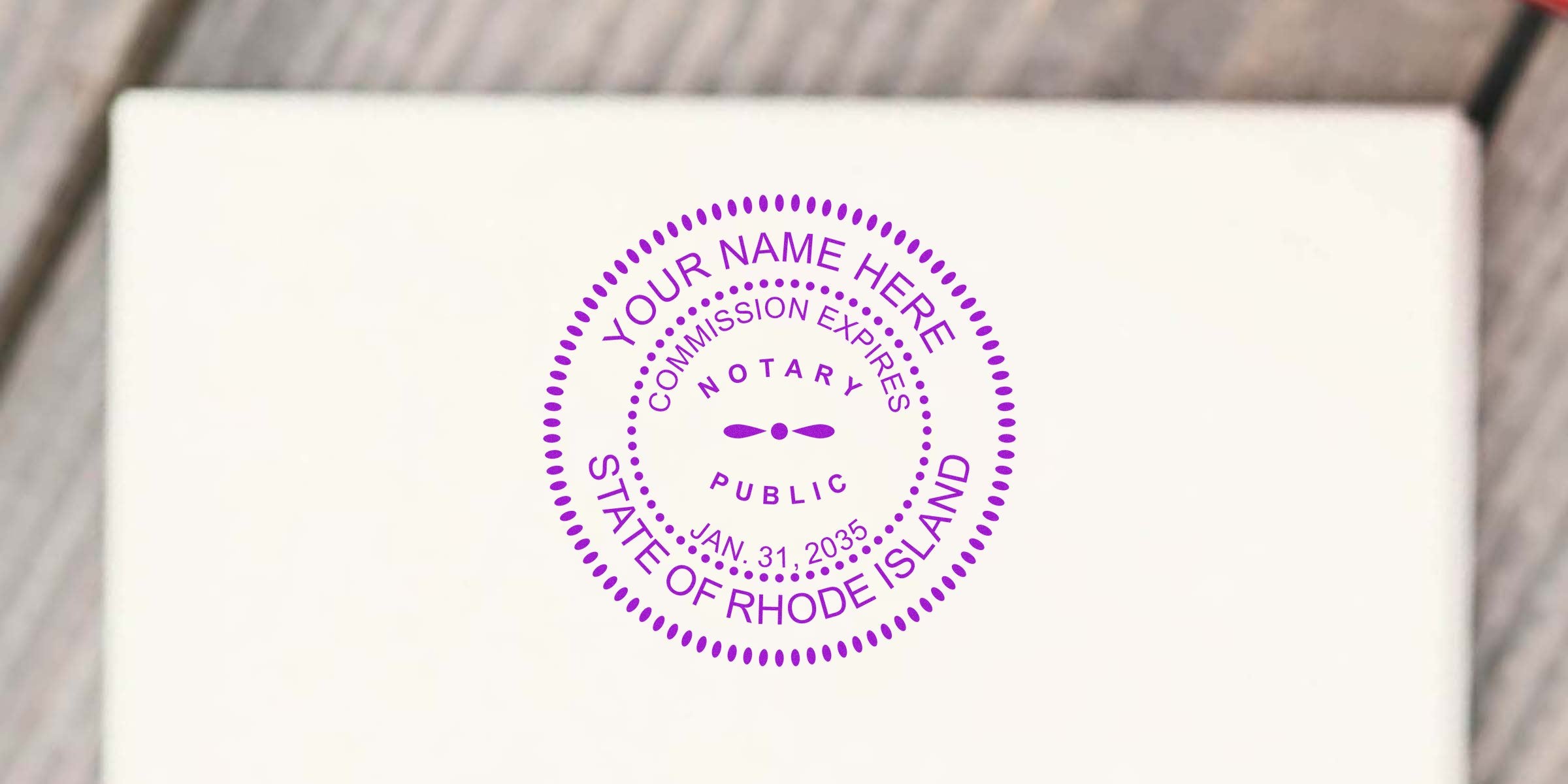 Purple circular notary public stamp mockup on white paper reading "Your Name Here," "Commission Expires," "Notary Public," "Jan. 31, 2035," and "State of Rhode Island."