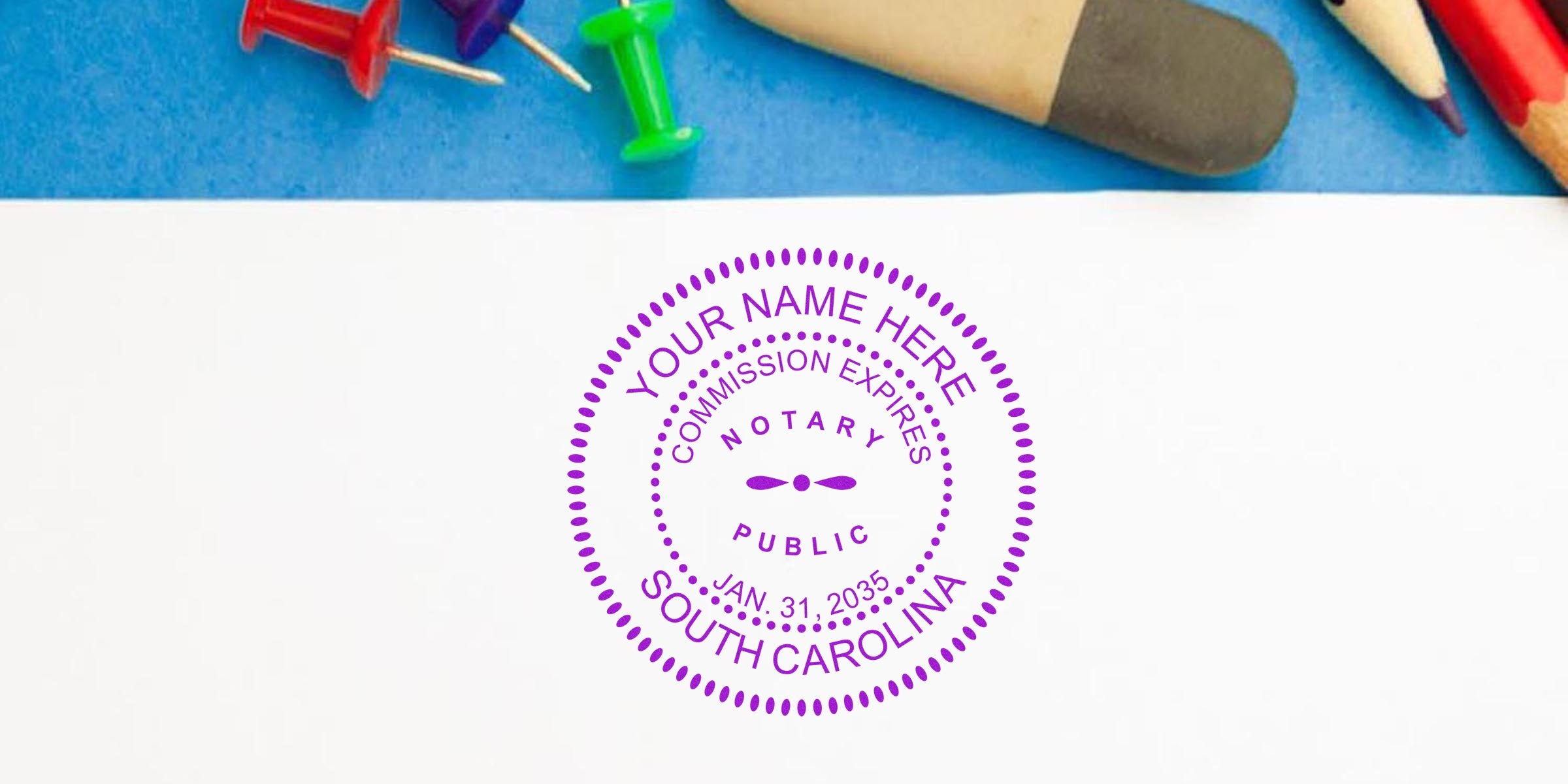 Purple circular notary public stamp reading "Your Name Here, Commission Expires Jan. 31, 2035, South Carolina" on white paper with blue background, colored pushpins and pencils.