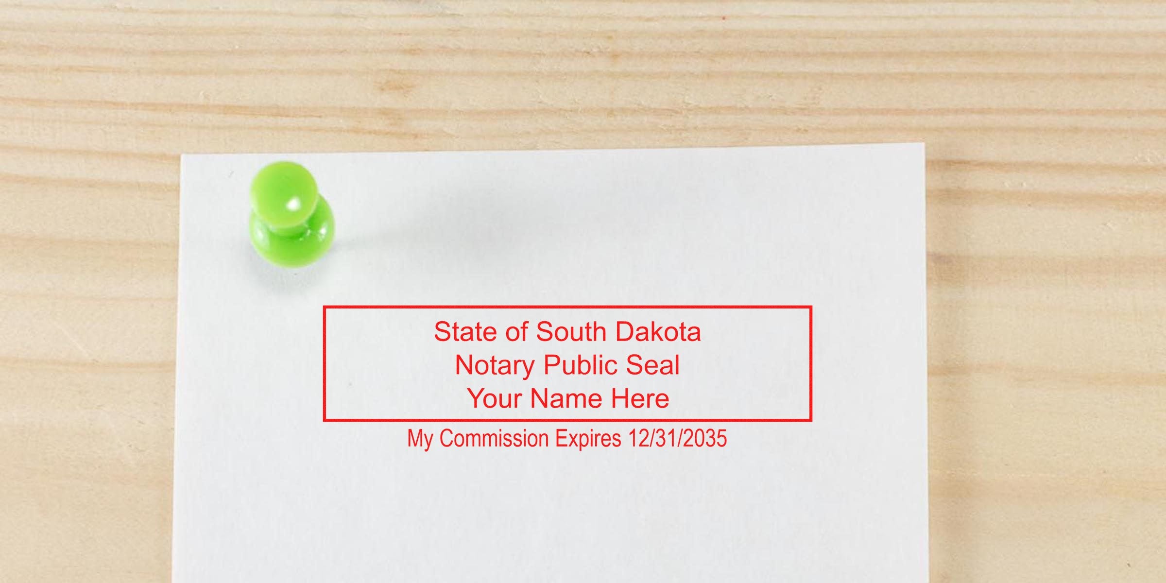 White sheet pinned with green pushpin on wooden background showing red rectangular notary seal text: "State of South Dakota Notary Public Seal Your Name Here My Commission Expires 12/31/2035"