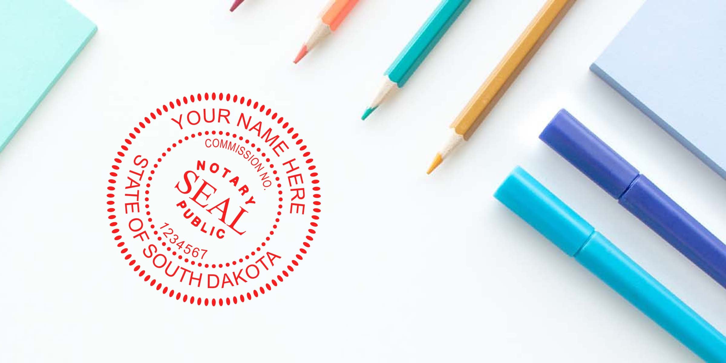 Red notary public seal stamped "State of South Dakota" beside colorful office supplies — blue and purple markers, teal and yellow pencils, and pastel sticky notes on a white background, flat lay for legal or notary office concept.