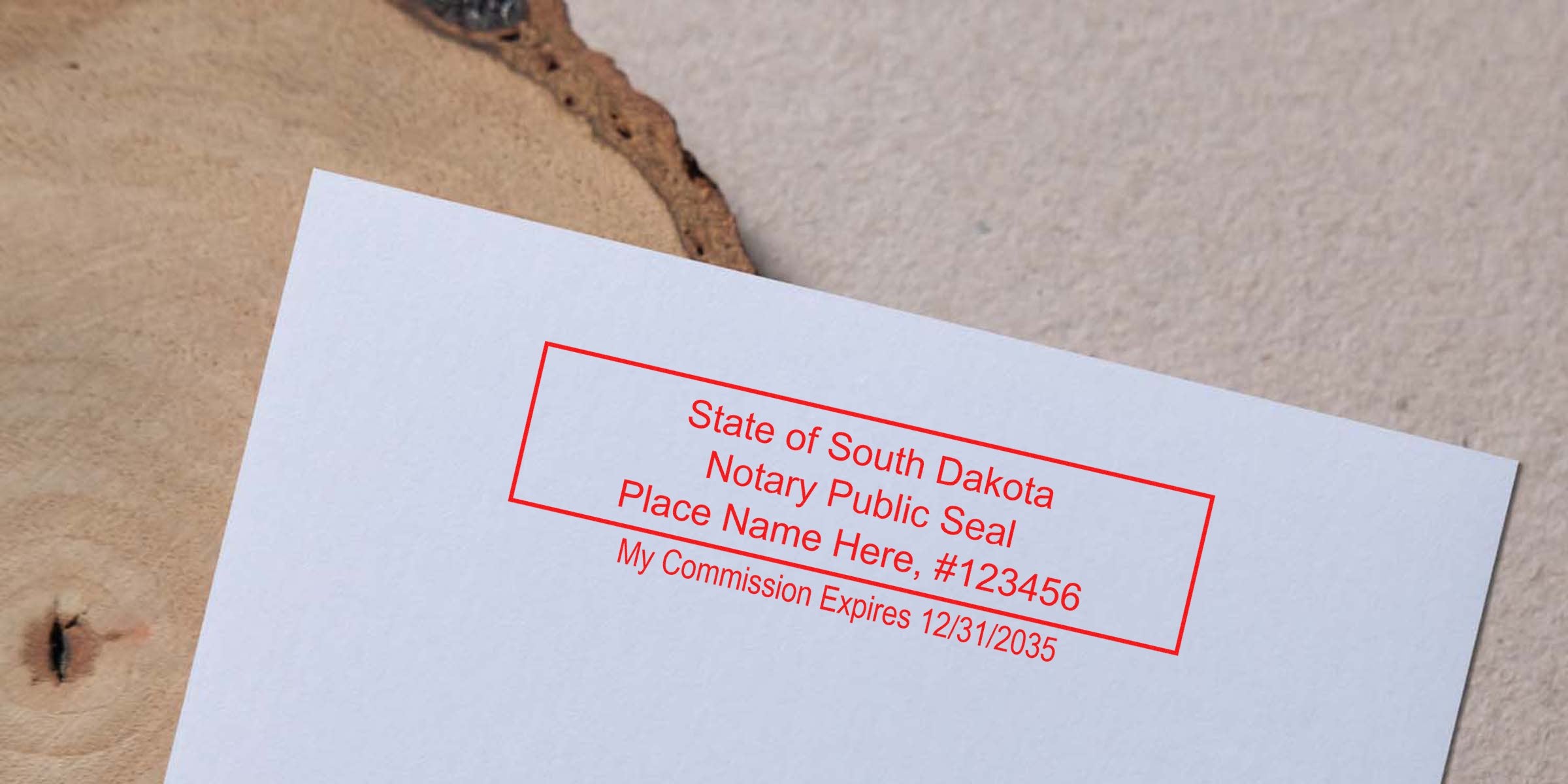White paper angled on a wood surface with a red rectangular South Dakota notary public seal stamp reading "State of South Dakota Notary Public Seal Place Name Here #123456 My Commission Expires 12/31/2035"