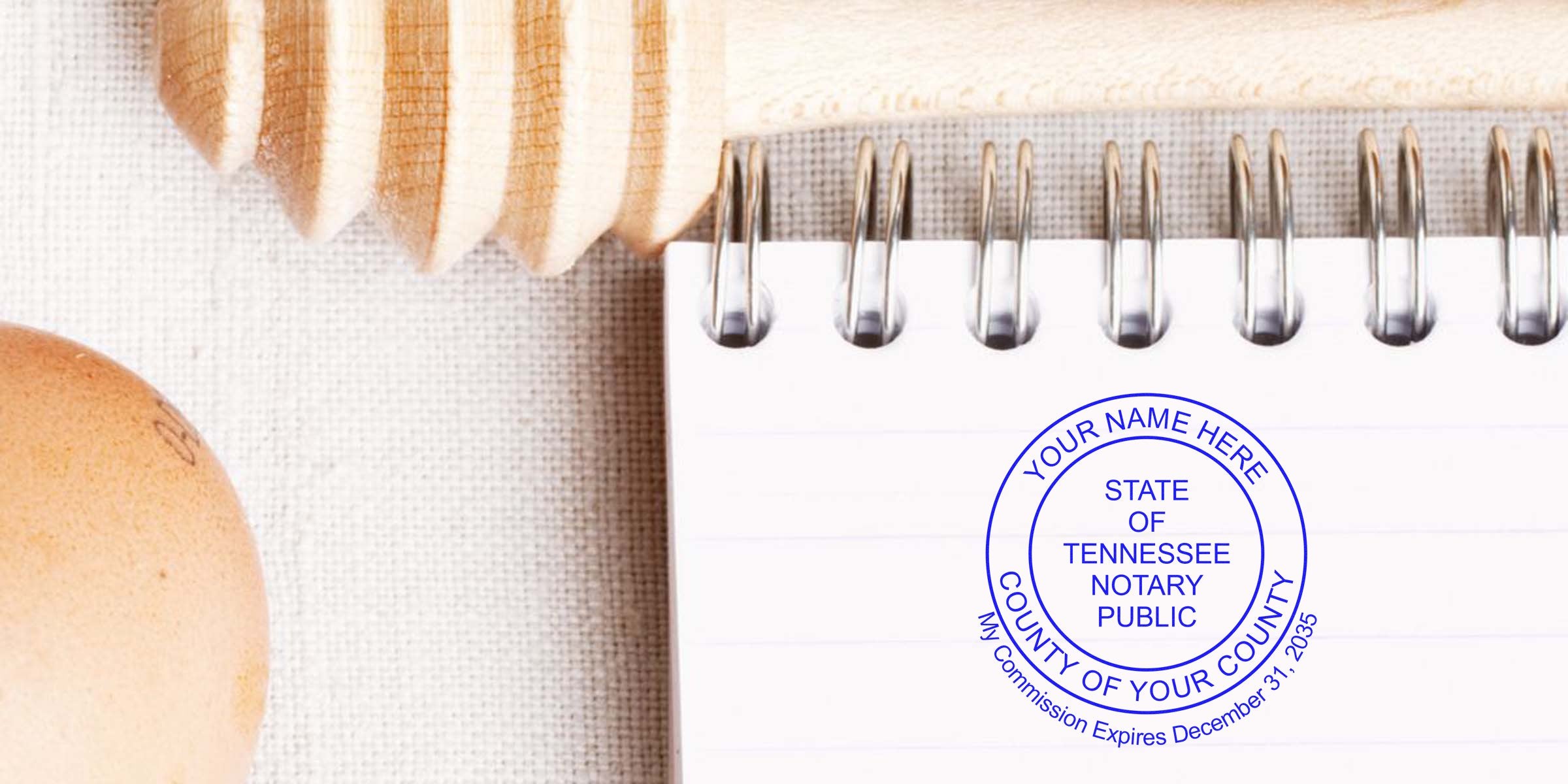 Close-up of a spiral-bound notebook page stamped with a blue "State of Tennessee Notary Public" seal on a textured linen surface, with a wooden honey dipper and a brown egg partially visible at the edges.