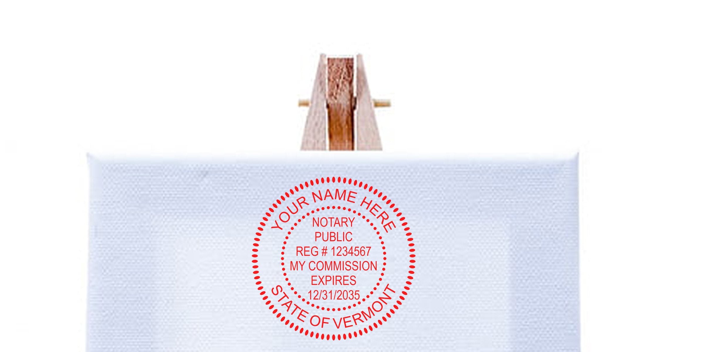 Red circular notary public stamp mockup reading "YOUR NAME HERE, NOTARY PUBLIC, REG # 1234567, MY COMMISSION EXPIRES 12/31/2035, STATE OF VERMONT" centered on white canvas on a small wooden easel — office stamp mockup.