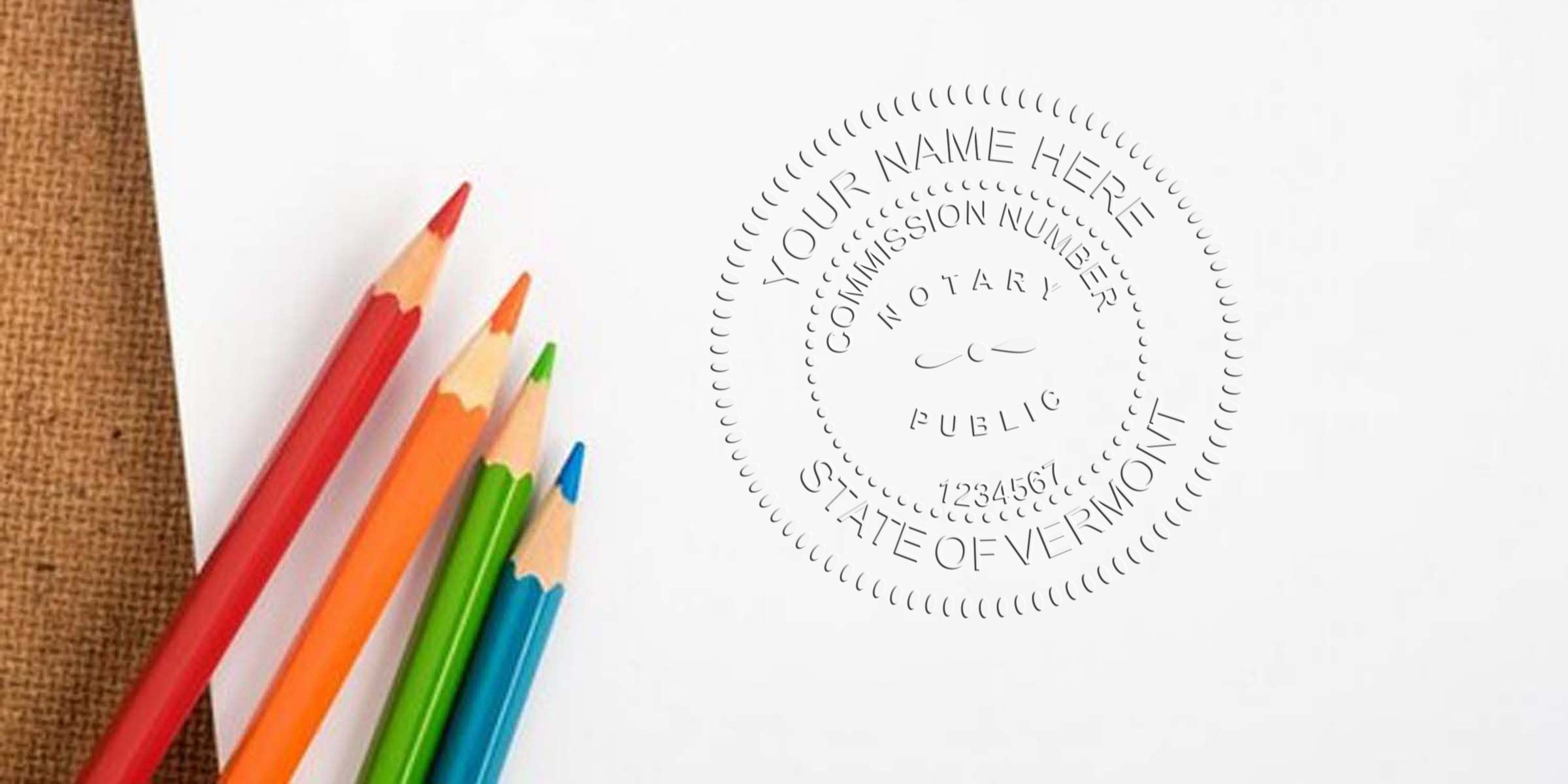 Close-up of red, orange, green and blue colored pencils resting on white paper beside an embossed notary seal mockup reading "State of Vermont" — stationery mockup for Vermont notary, embossing stamp, legal document design.