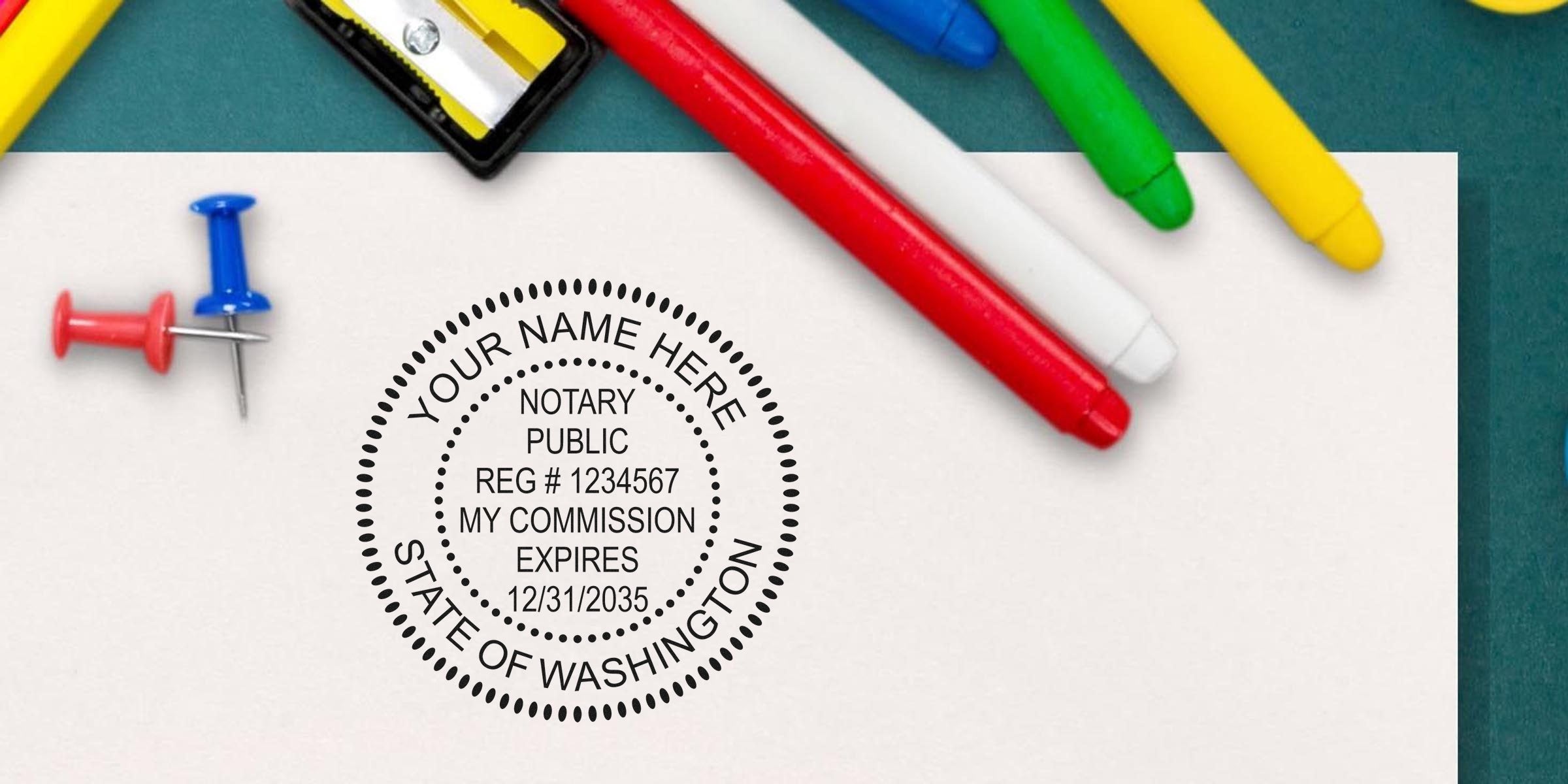 Notary public round stamp imprint on white paper reading "State of Washington" beside colorful markers, push pins and a pencil sharpener — document notary concept.
