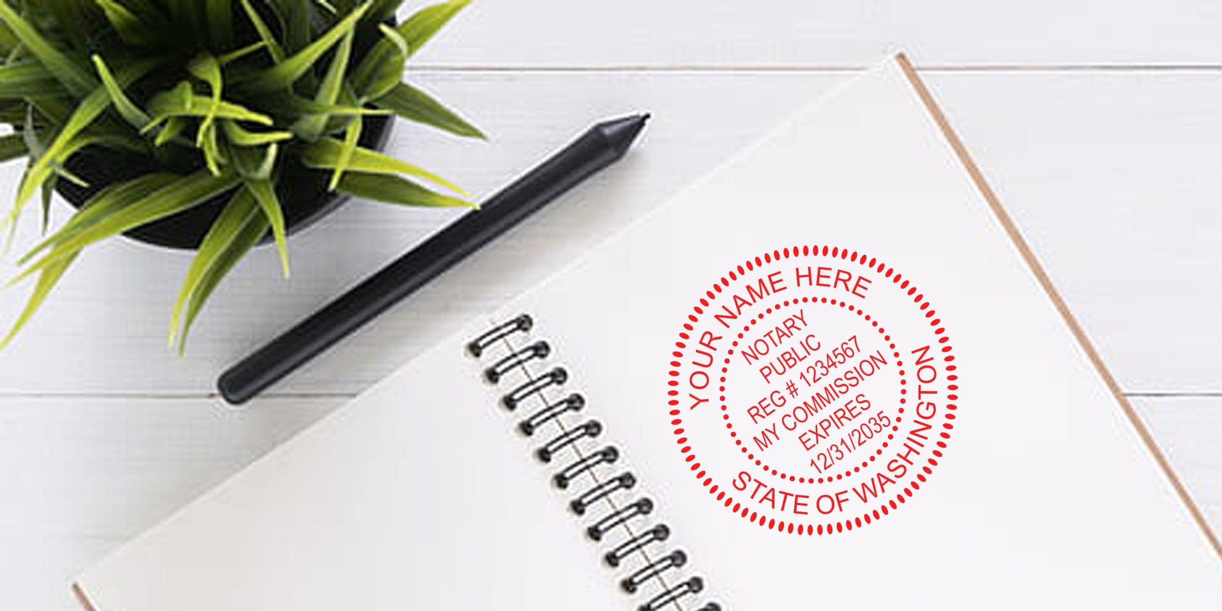 Close-up of white spiral notebook with black pen and potted plant, featuring red personalized notary seal stamp reading "Your Name Here" and "State of Washington" on a white desk.