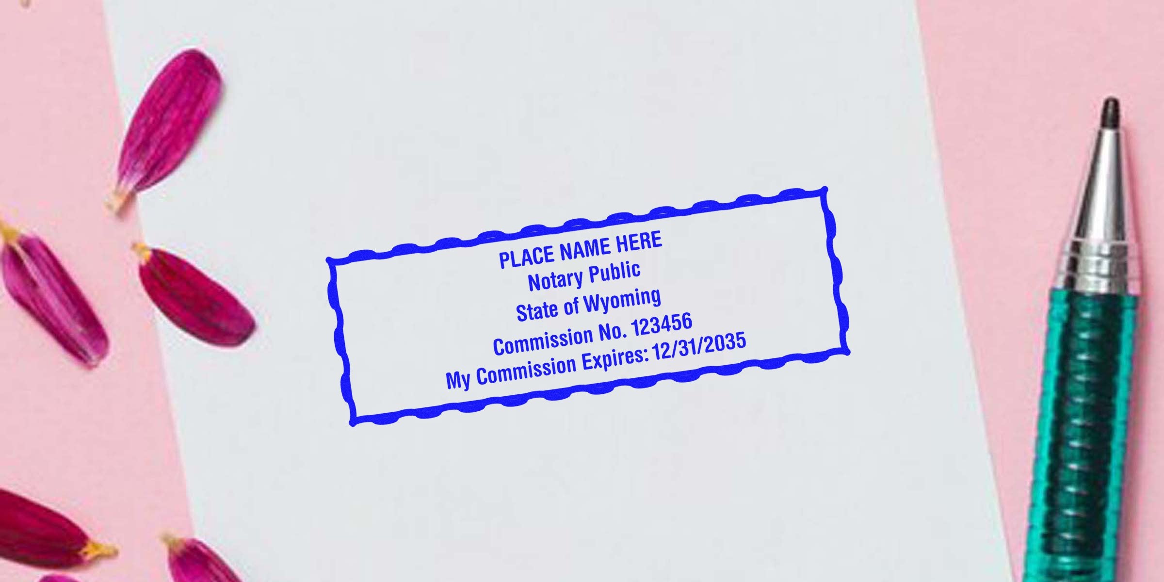 Blue rectangular notary stamp mockup on white paper reading "Notary Public State of Wyoming, Commission No. 123456, Expires 12/31/2035" with teal pen and pink flower petals