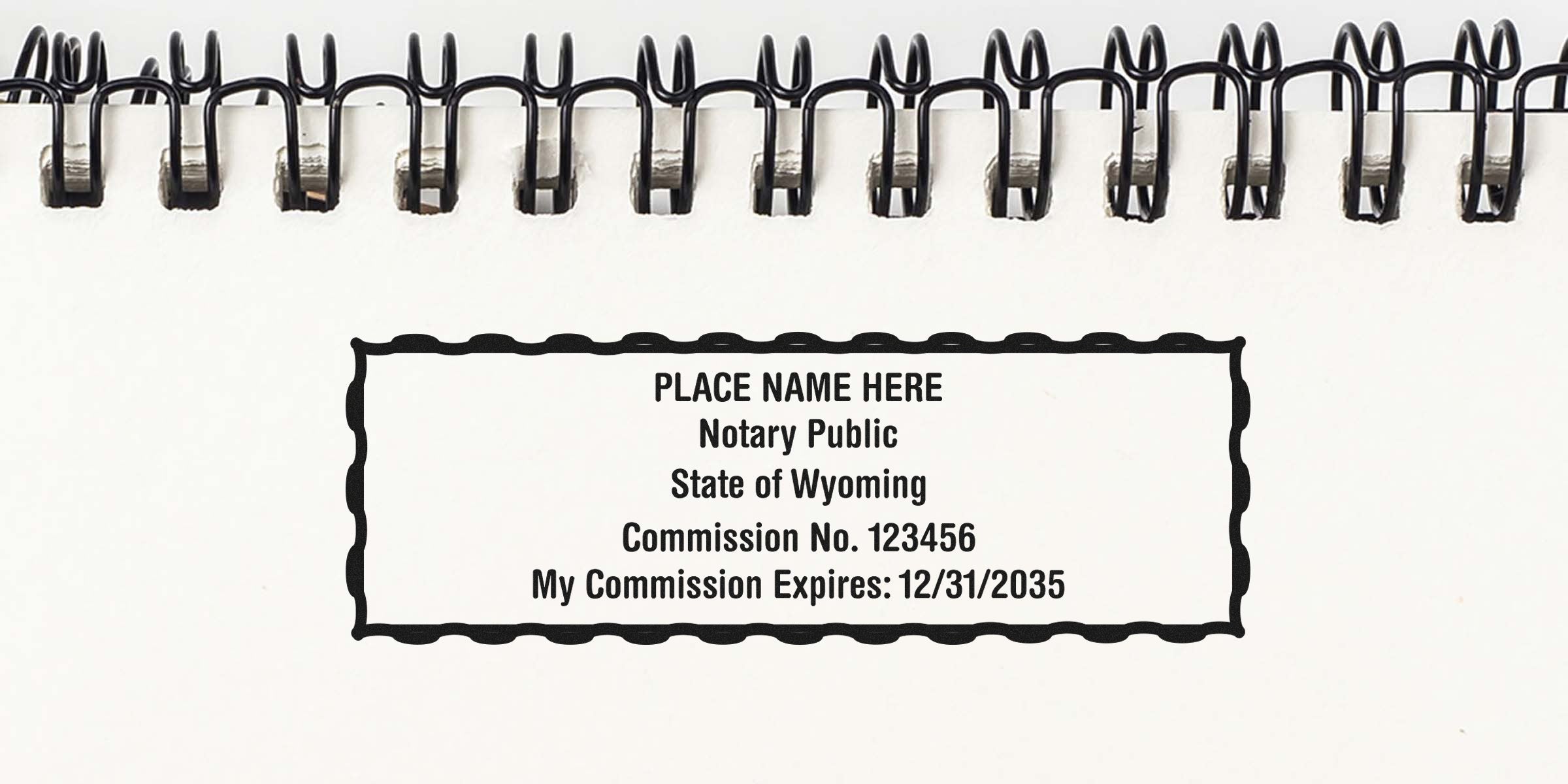Spiral-bound notebook page showing a notary public stamp sample reading "PLACE NAME HERE, Notary Public, State of Wyoming, Commission No. 123456, Expires 12/31/2035"
