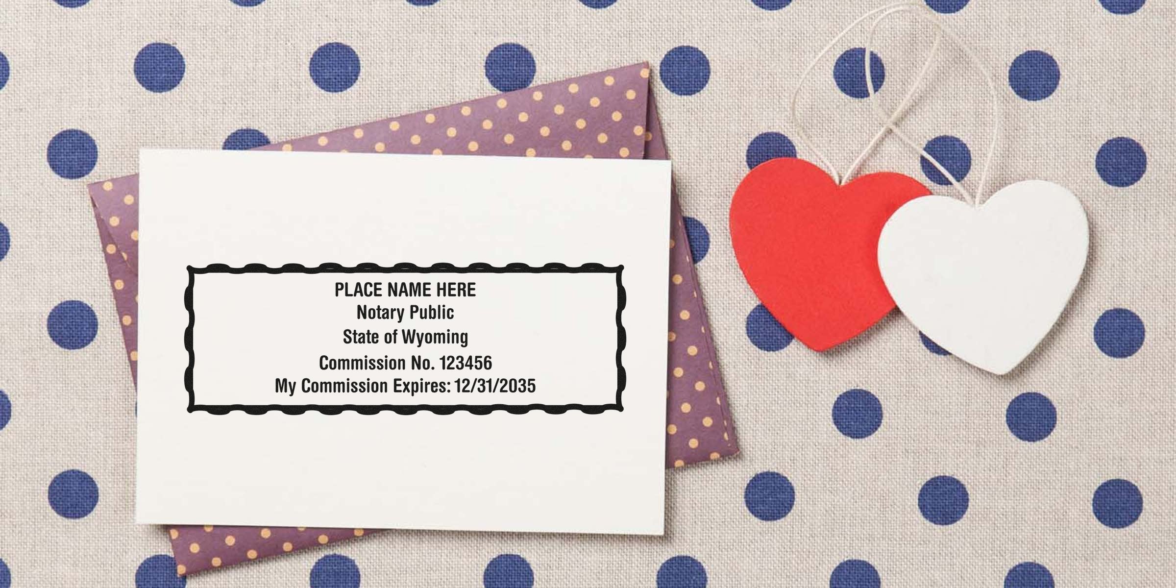 Mockup notary public stamp sample card (State of Wyoming) on purple polka-dot envelope, two hanging red and white heart tags on beige polka-dot fabric