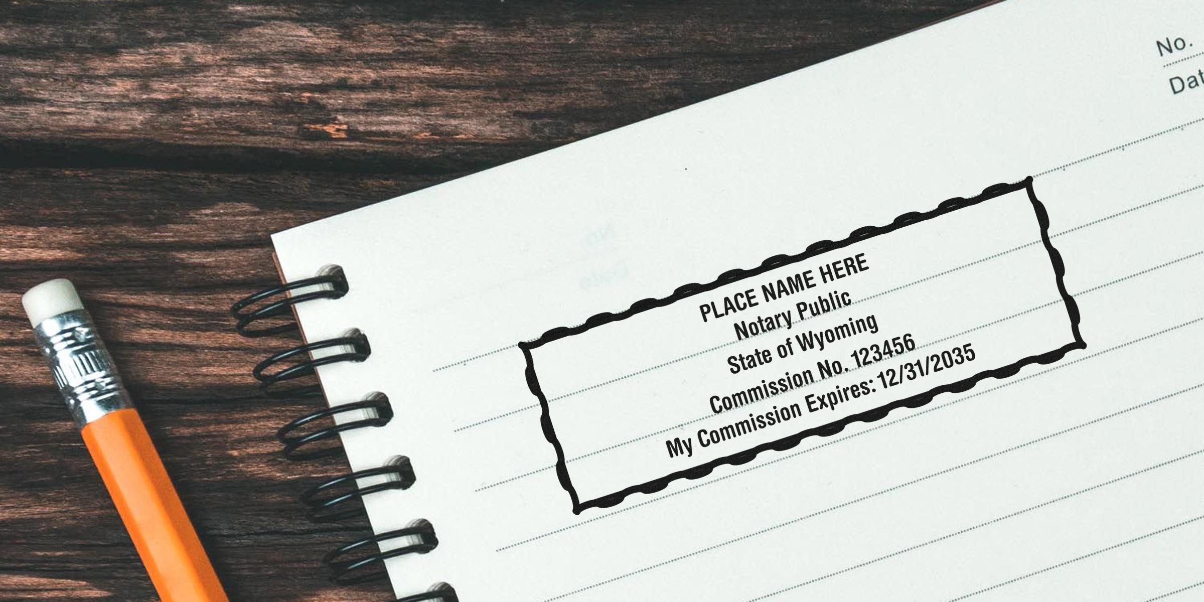 Spiral notebook on wooden desk with pencil and a stamped notary public mockup reading "PLACE NAME HERE, Notary Public, State of Wyoming, Commission No. 123456, Expires 12/31/2035"