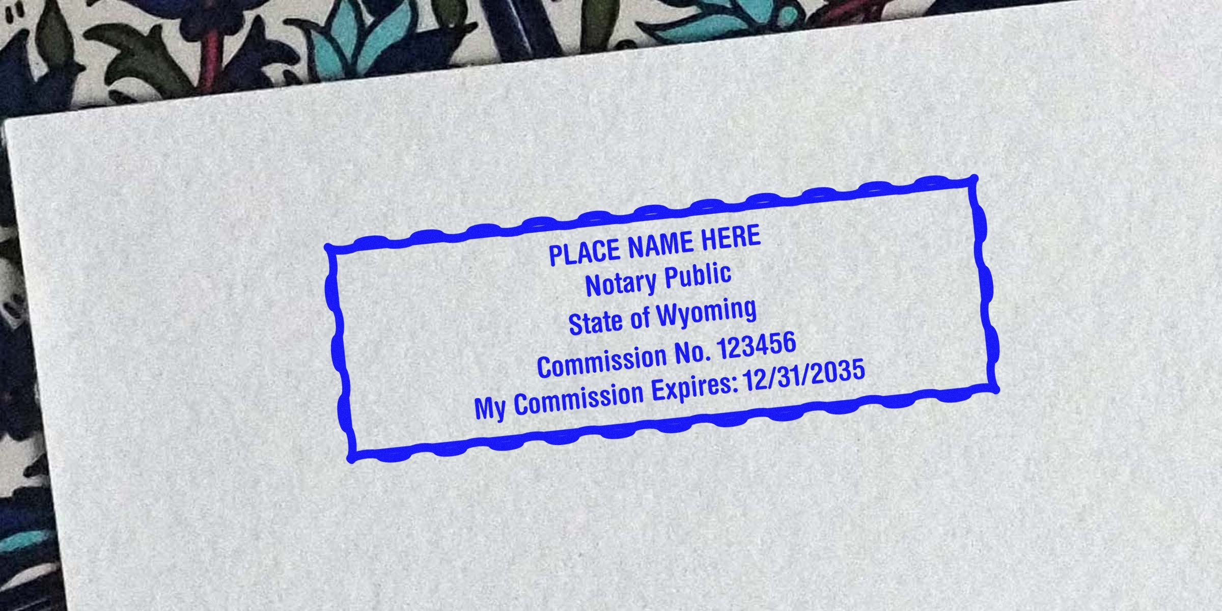 Blue rectangular notary stamp on paper reading "Place Name Here, Notary Public, State of Wyoming, Commission No. 123456, My Commission Expires: 12/31/2035"