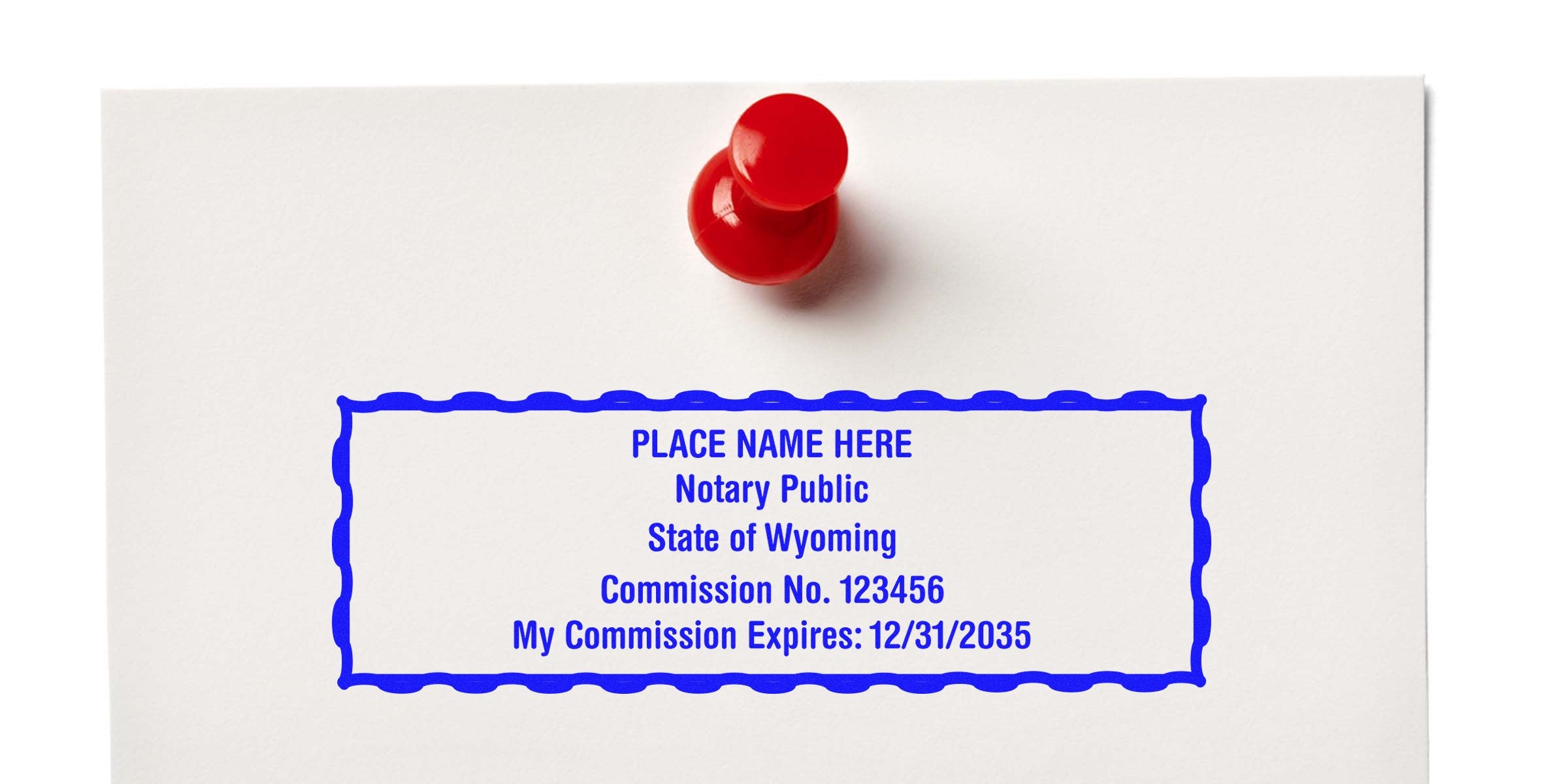 Red pushpin holding white paper with blue notary stamp mockup reading "PLACE NAME HERE Notary Public State of Wyoming Commission No. 123456 Expires 12/31/2035"