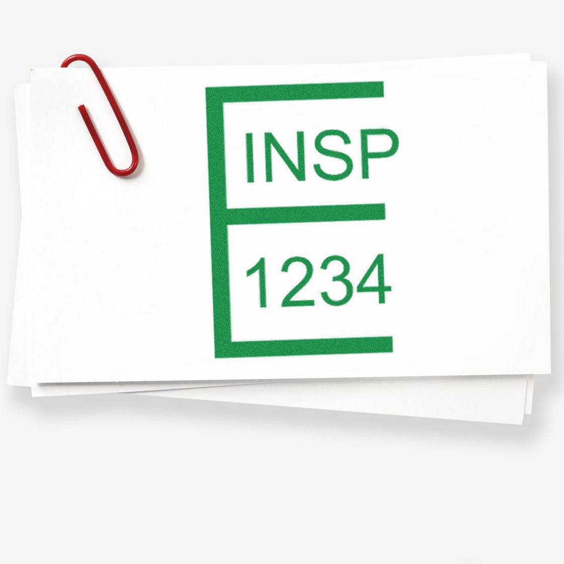 Green INS P 1234 stamp seal on stacked white paper with a red paperclip