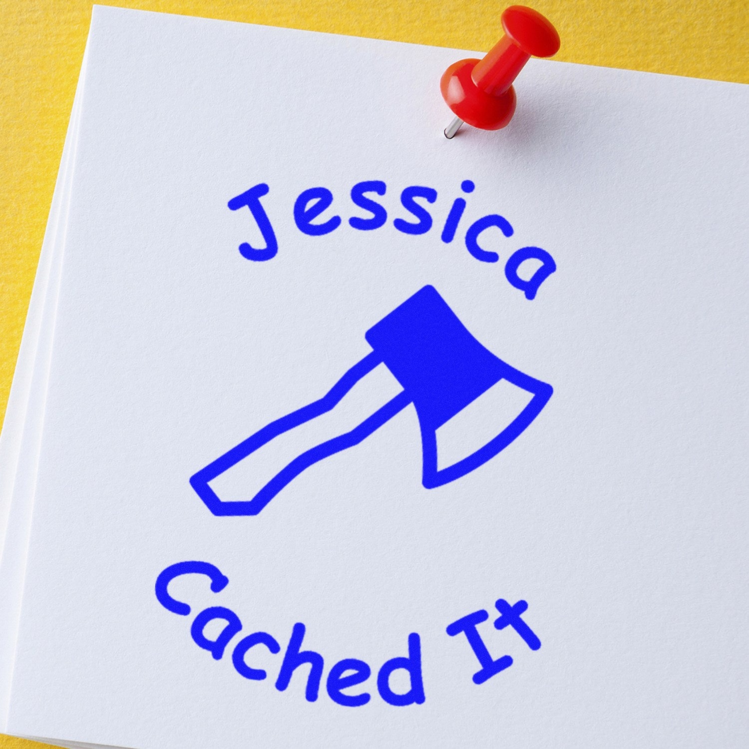 Red pushpin on white sheet with blue Jessica Caching IT stamp seal and axe logo, on yellow background.