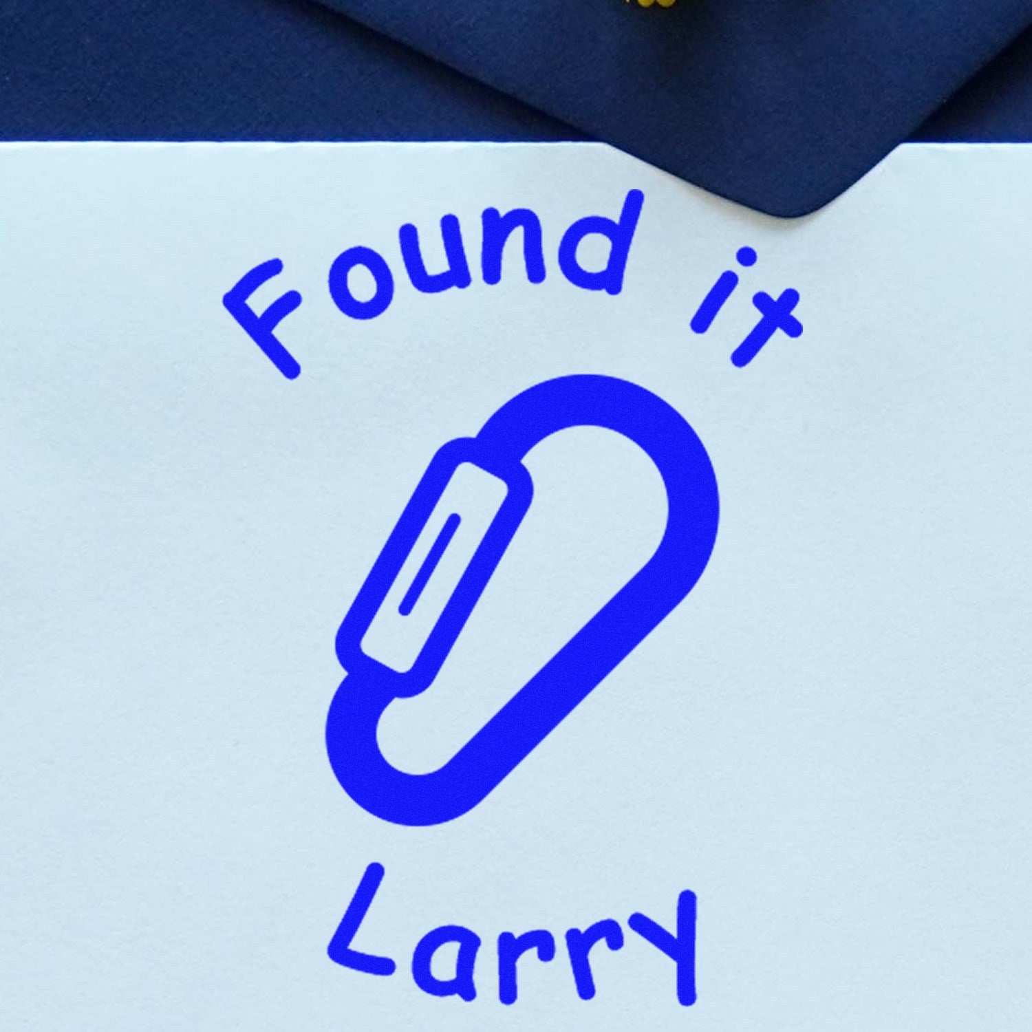 Blue custom stamp seal with paperclip icon, reading Found it and Larry in blue on white paper.