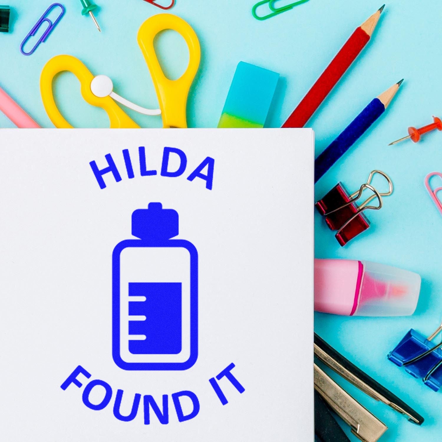 HILDA FOUND IT blue stamp and seal logo on white sheet, surrounded by colorful stationery on aqua background.