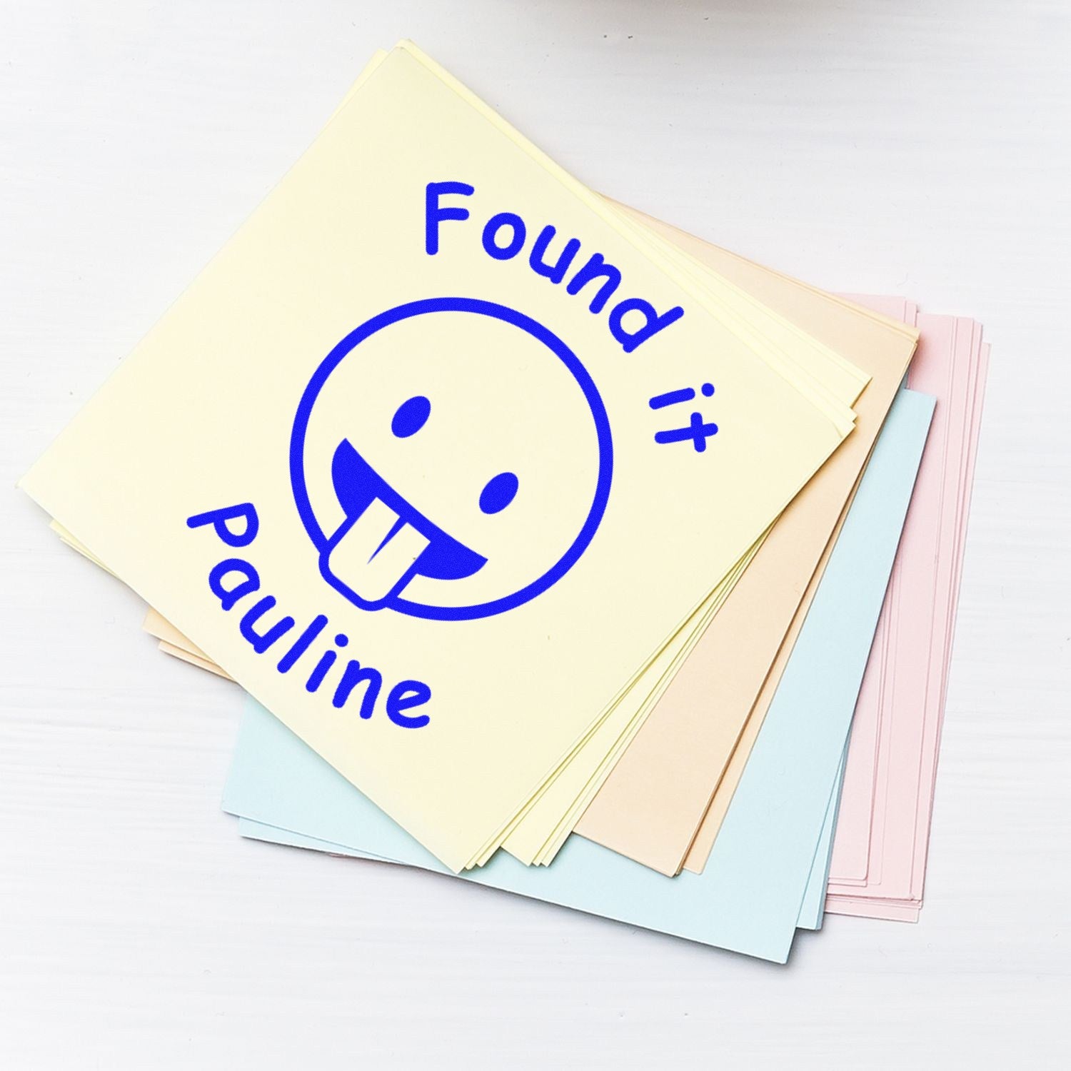 Pastel office stamp sheets with blue Found it seal and smiley face, stacked on a white background.