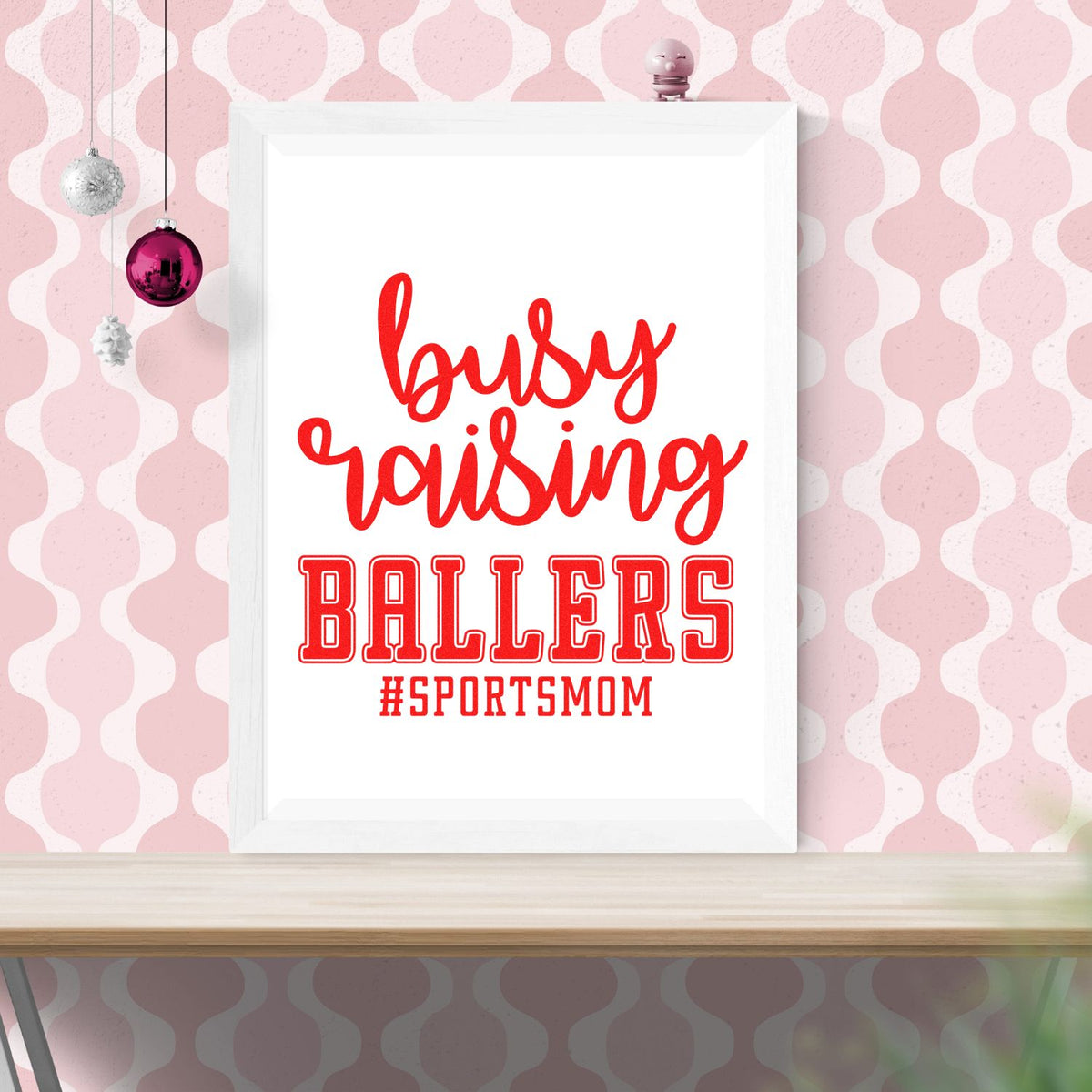 Pink and white framed custom stamp and seal design with red busy raising BALLERS #SPORTSMOM lettering.