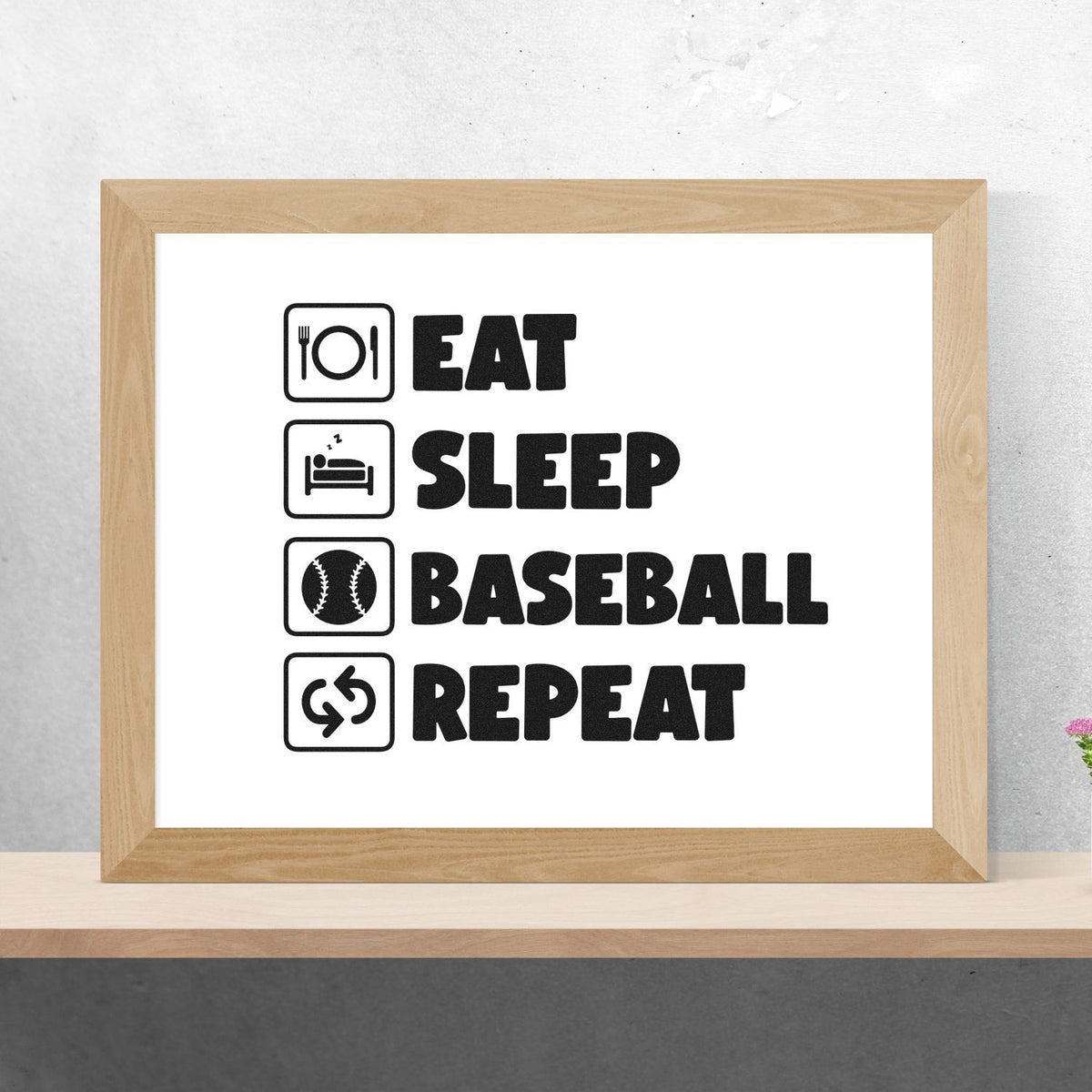 Black stamp and seal wall art in a light wood frame, with icons and bold text: Eat, Sleep, Baseball, Repeat.