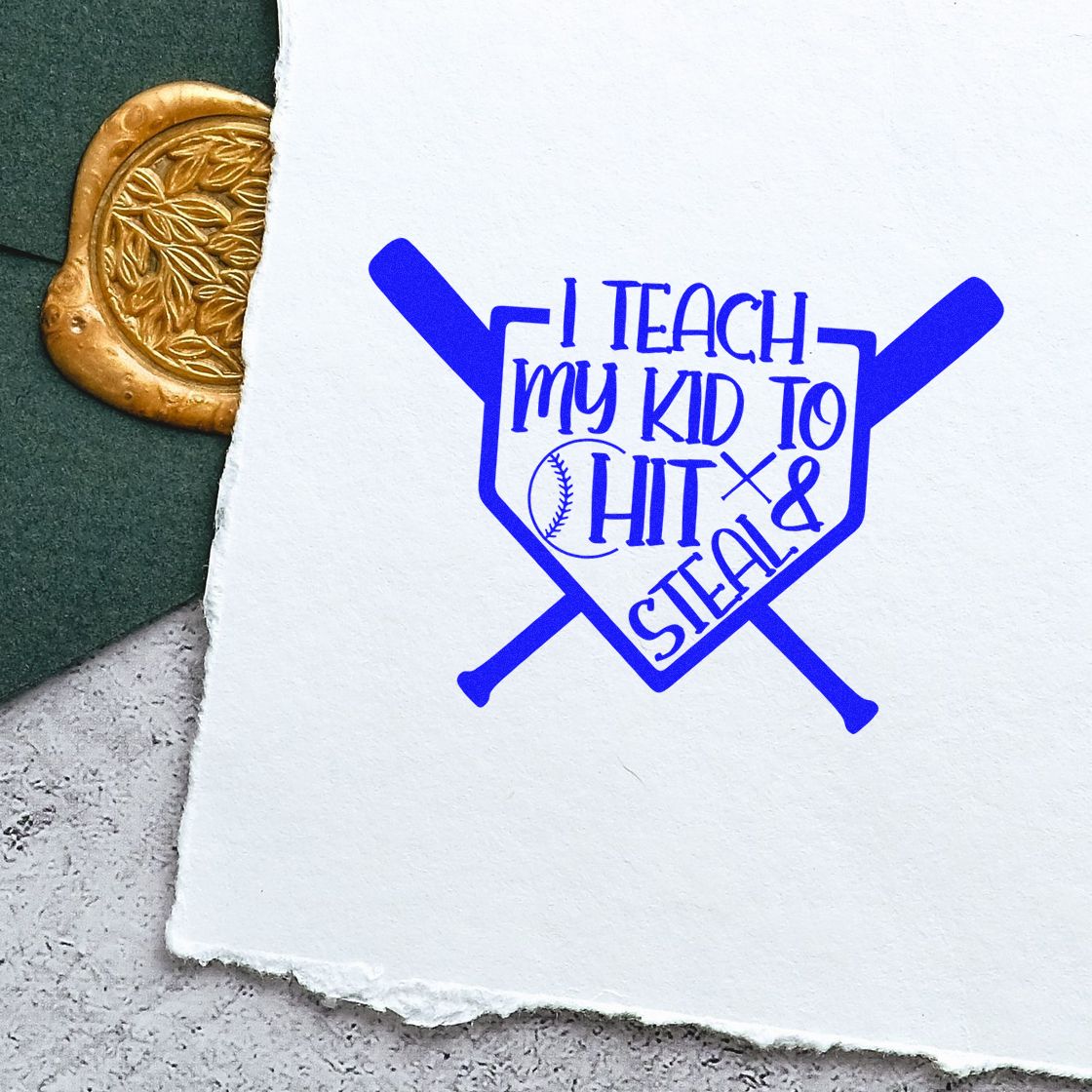 Blue baseball stamp reading I teach my kid to hit & steal beside a gold embossed seal on textured white paper.
