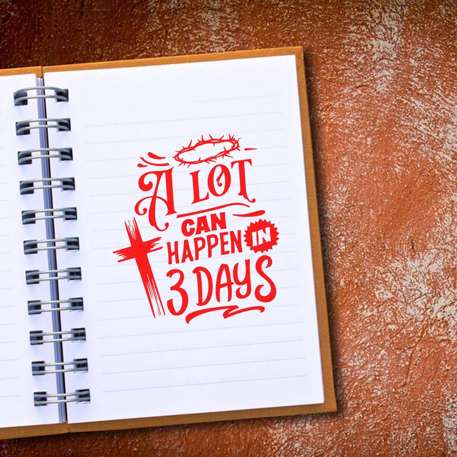Red religious stamp seal reading A lot can happen in 3 days on a white spiral notebook, with crown of thorns and cross.