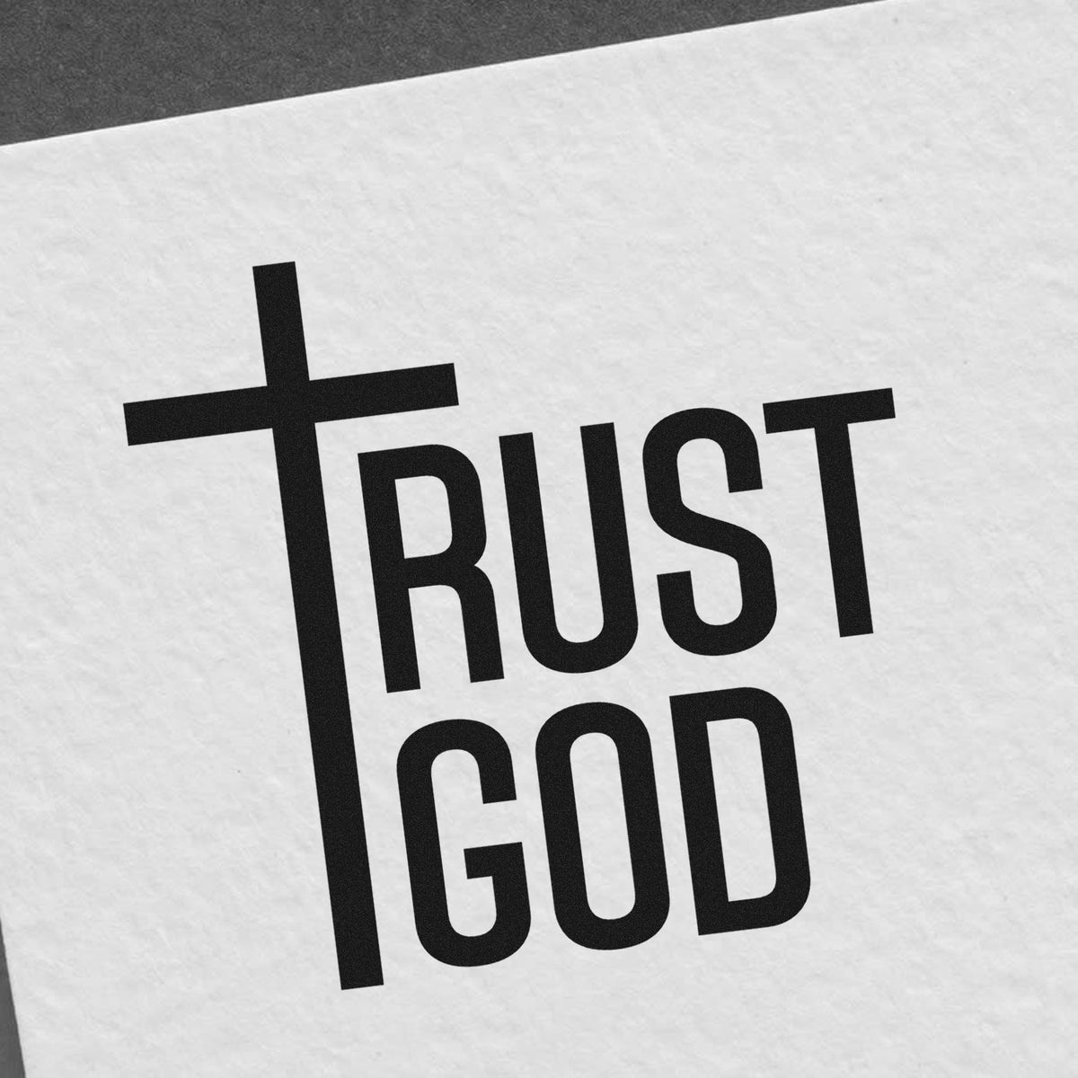 Black TRUST GOD stamp seal with cross on white textured paper