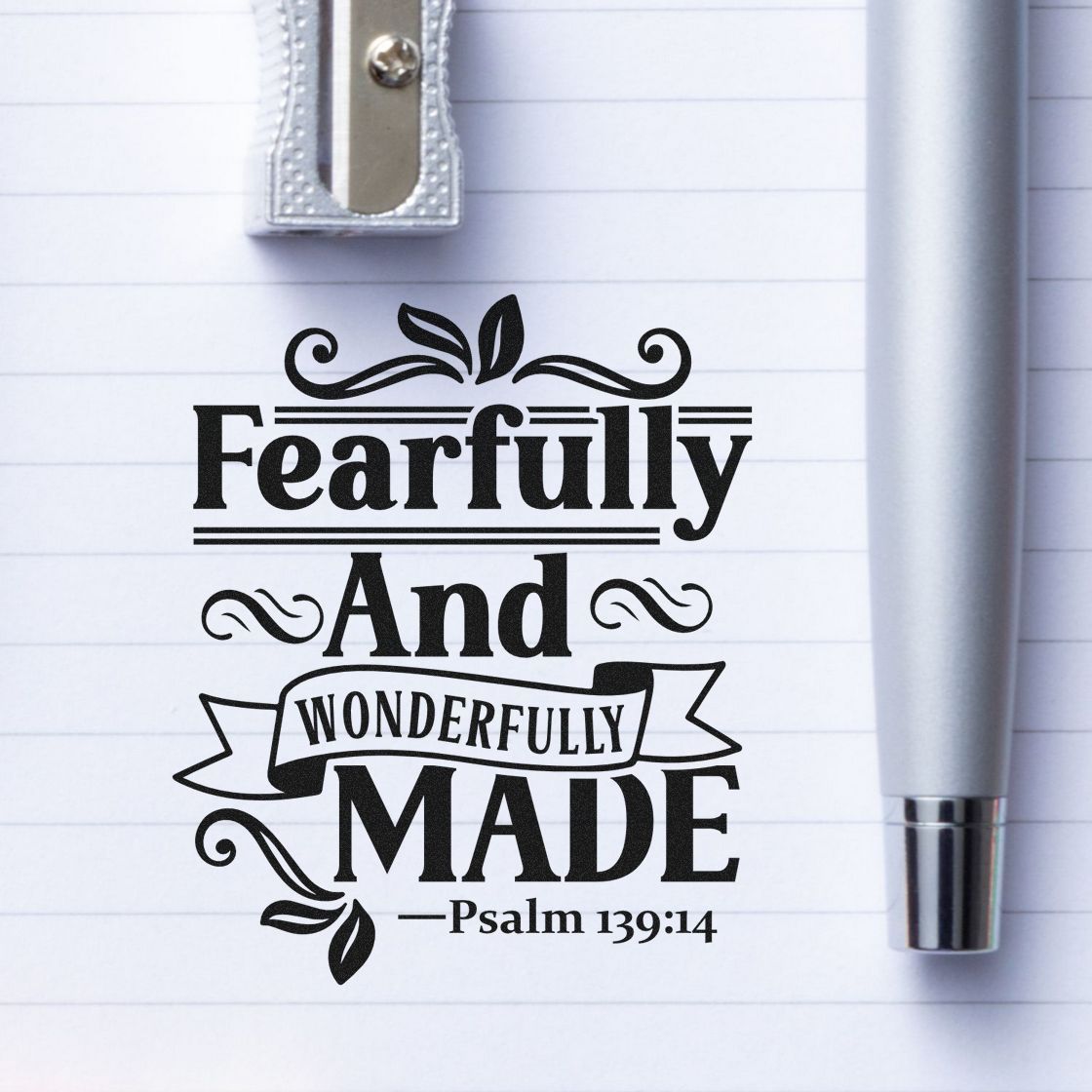Slim Pre-Inked Fearfully And Wonderfully Made Leaf Accents Stamp imprint stamped in black ink. Leaves, scrolls, and a ribbon accent "Fearfully and wonderfully made," with Psalm 139:14.