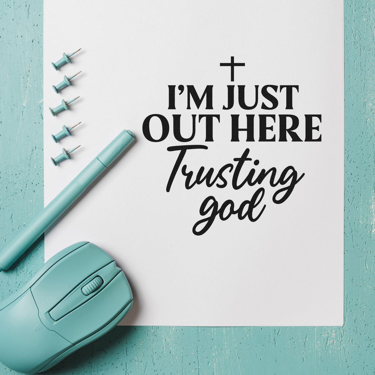 Teal stamp and seal products beside a white card with black cross and Im just out here trusting God text.