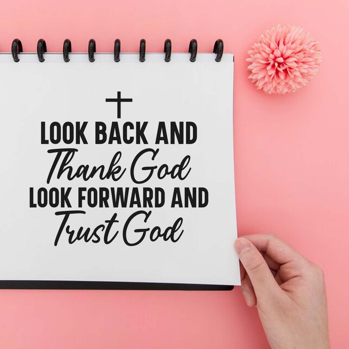 Christian quote stamp on white spiral notebook, with pink flower seal, against a soft pink background.
