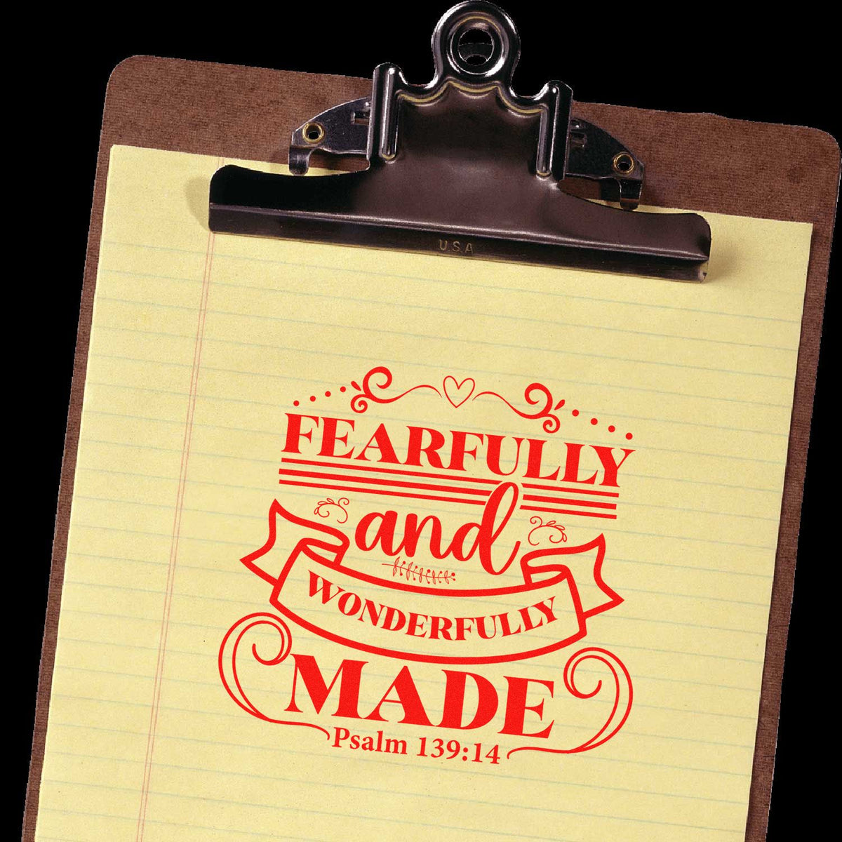 Red Fearfully and Wonderfully Made Psalm 139:14 stamp seal on yellow lined paper clipped to a brown clipboard.