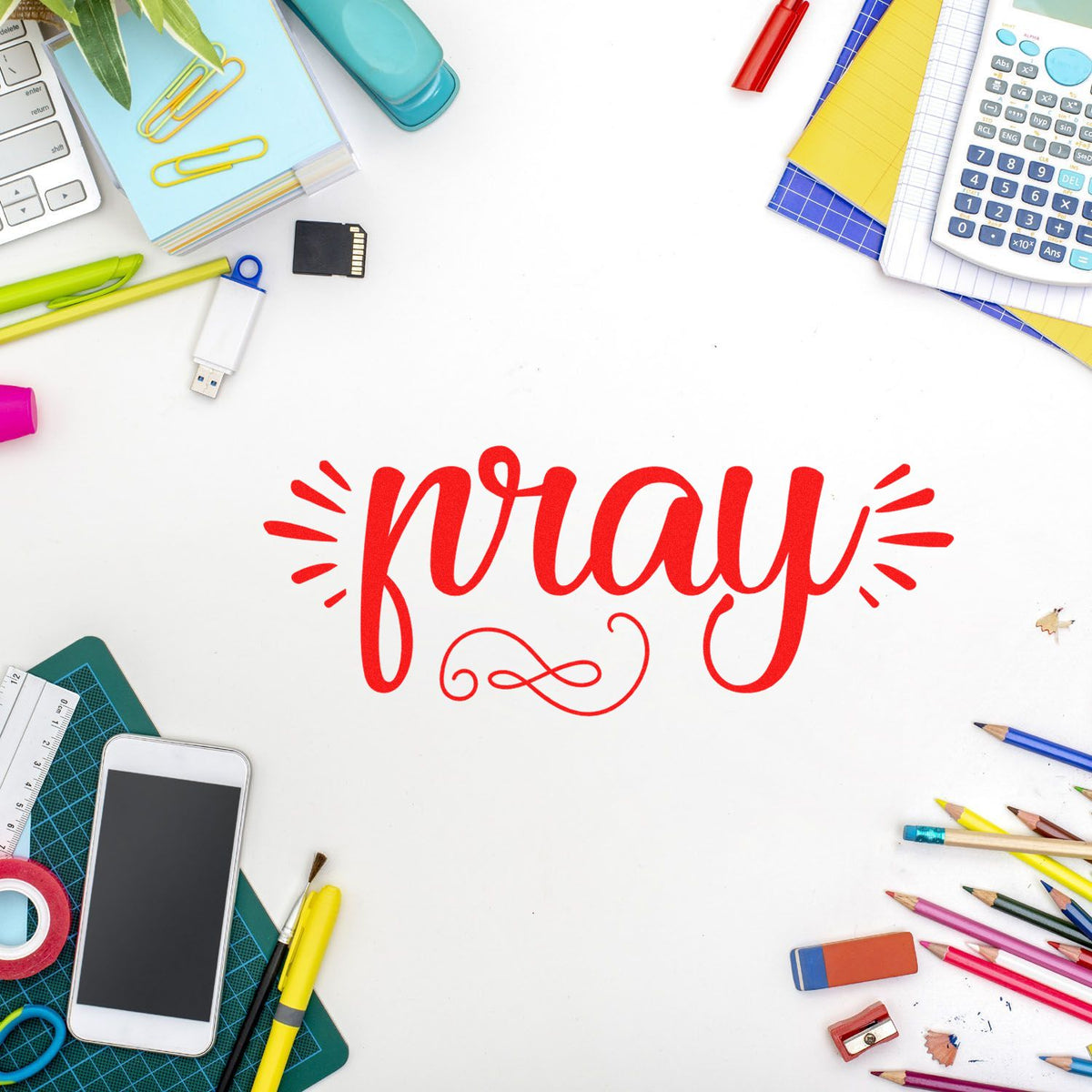 Red pray stamp seal on white, surrounded by colorful stationery, pencils, calculator, and craft tools.